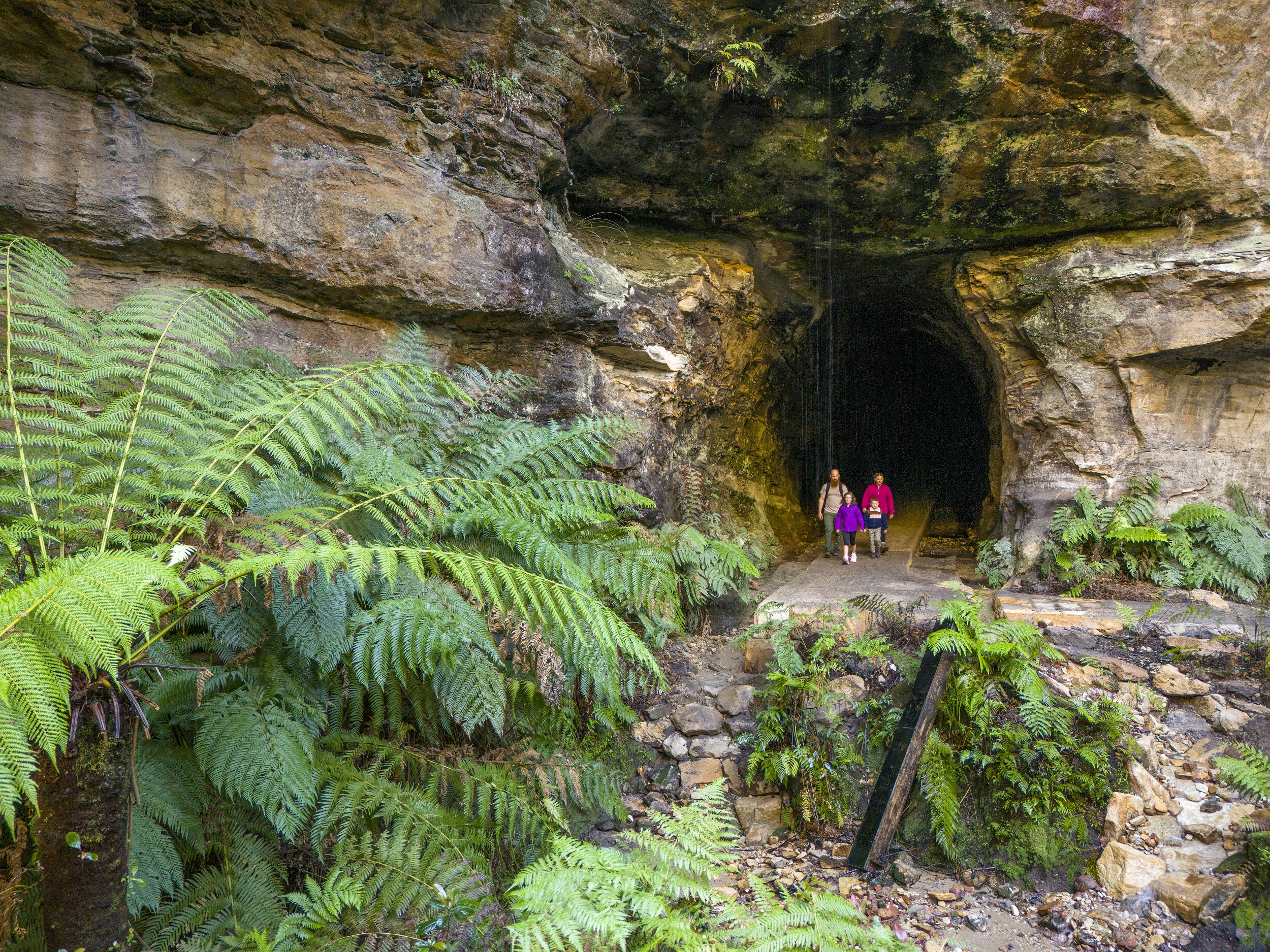 A family outside the entrance to Glow Worm Tunnel. Photo credit: John Spencer/DCCEEW