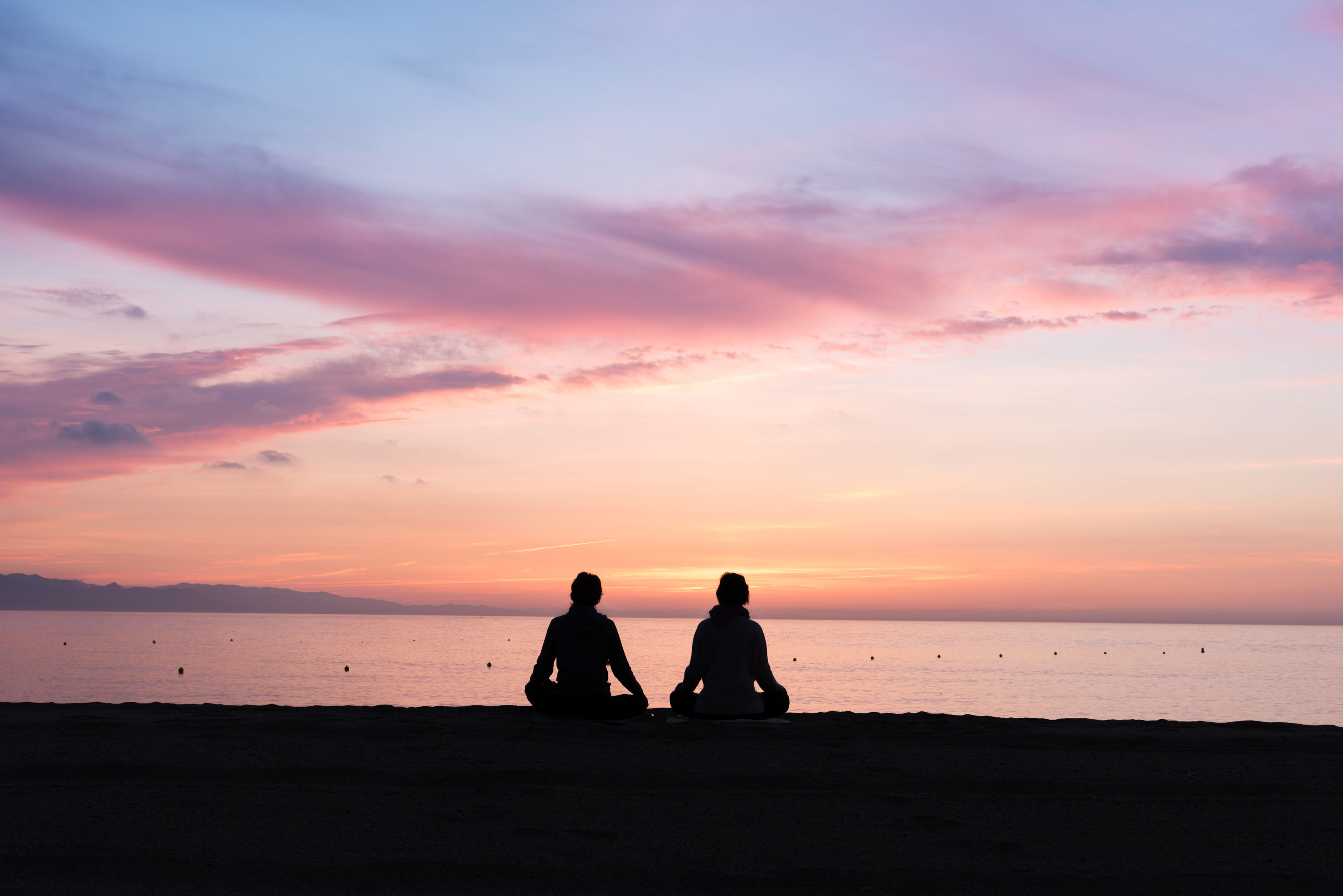 Two people meditating by the ocean. Photo: © Seb Ruiz