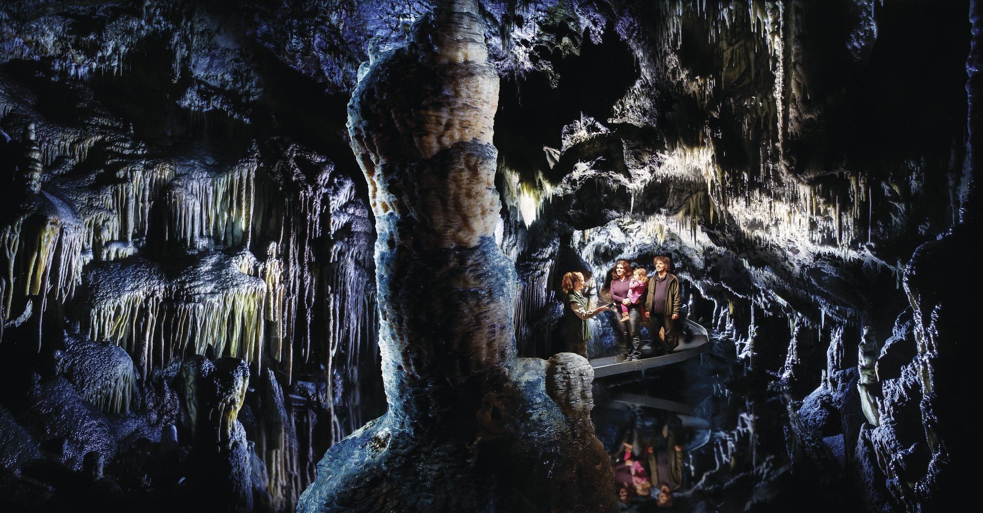 Family tour reflected in water at Yarrongobilly Caves