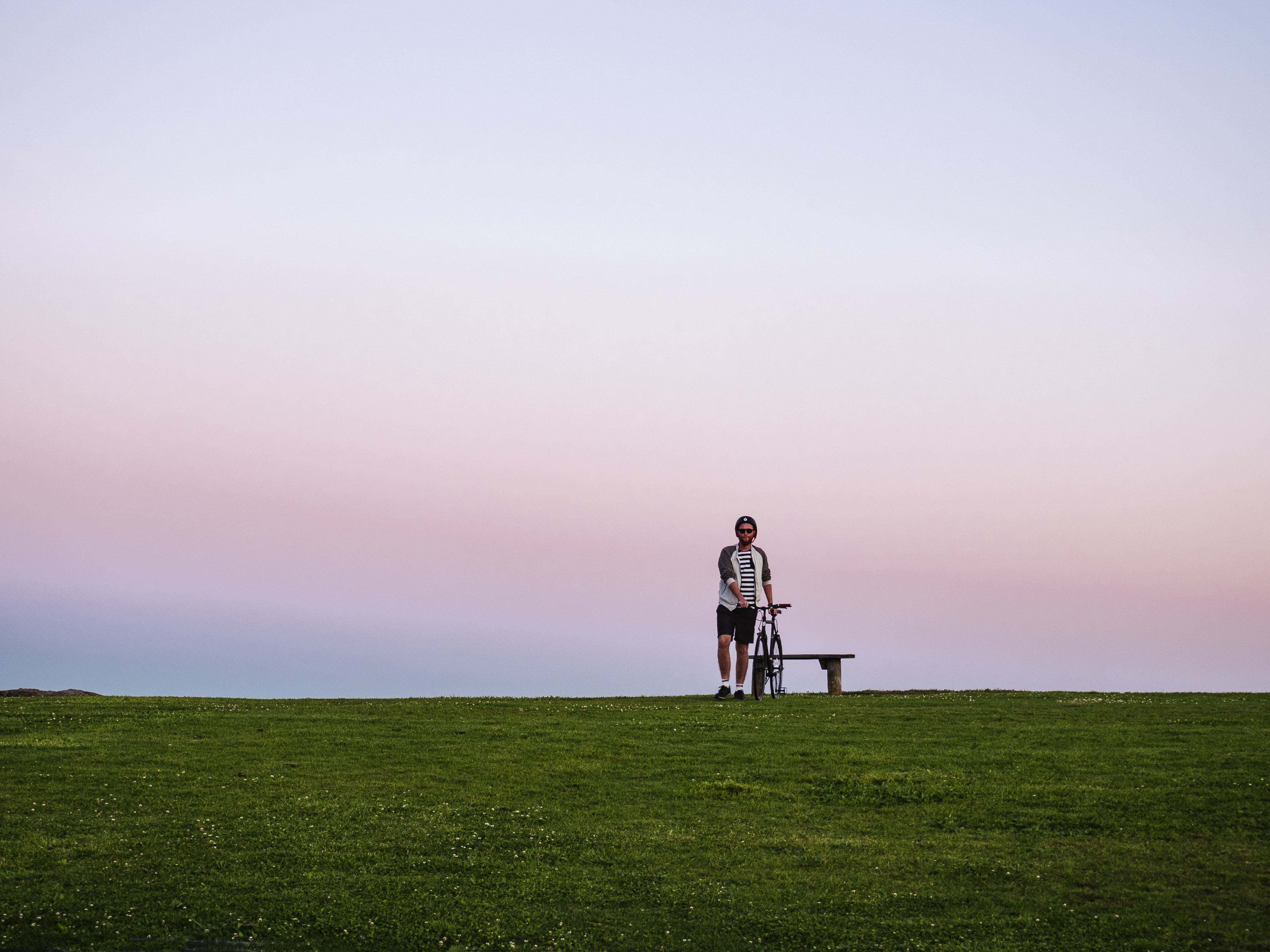 Person resting with bike near a seat along the La Perouse Loop. Photo: Nick Alfred