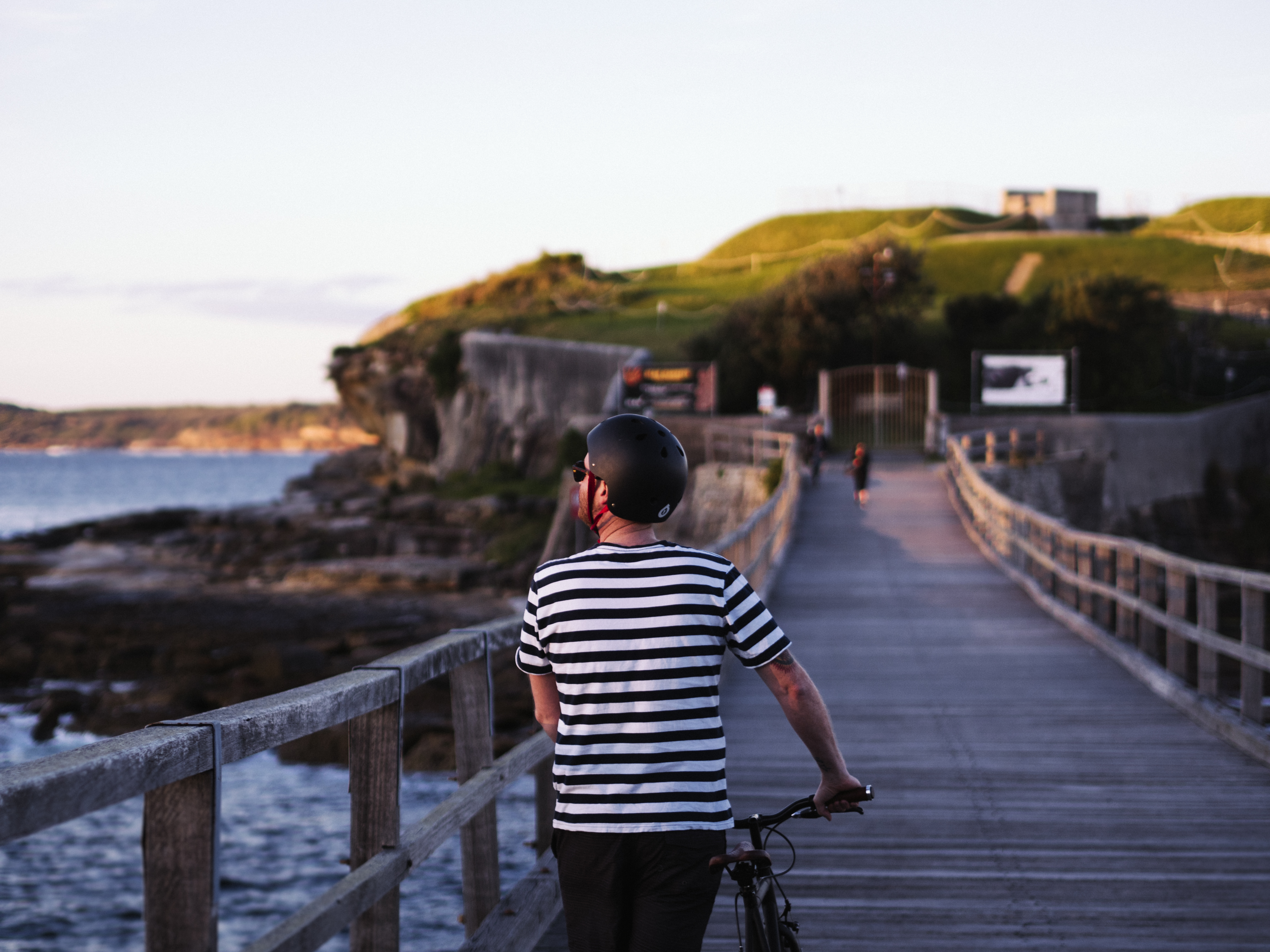 Person pushing bike towards Bare Island, Kamay Botany Bay National Park. Photo: Nick Alfred