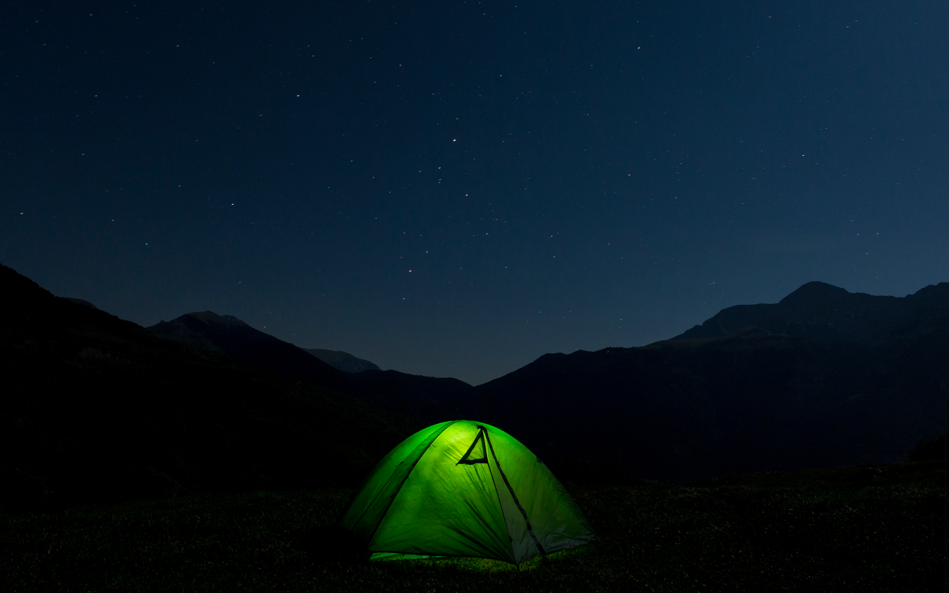 Light on inside a tent at night. Credit Stocksy / Jordi Rulló