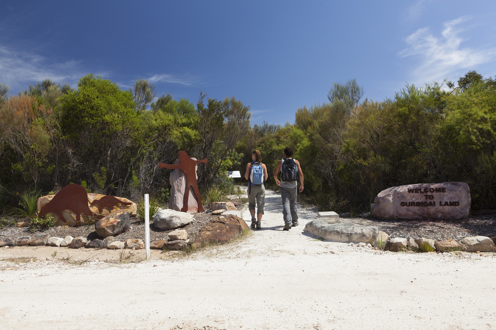 Two people walking towards Basin Aboriginal art site in Ku-ring-gai Chase National Park. Photo credit: David Finnegan/DPIE