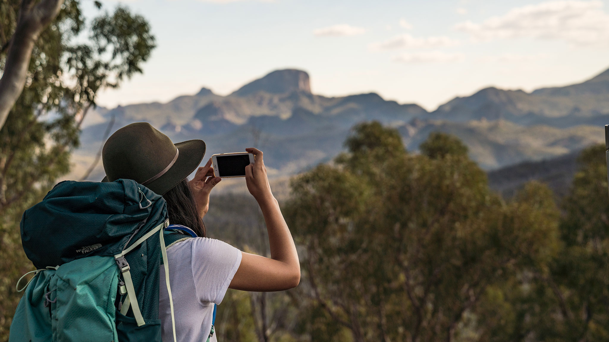 Hiker taking a photo in Warrumbungle National Park. Photo credit: Rob Mulally/DPIE