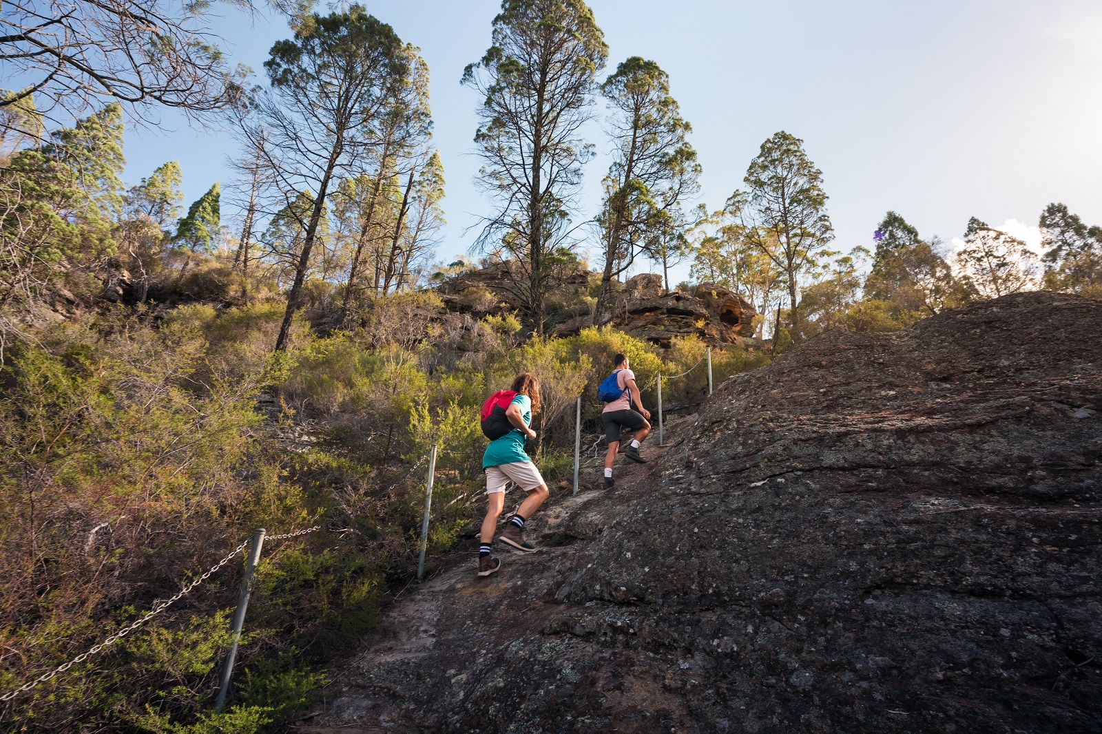 Two guys hiking up the pagoda outcrop. Photo credit: Daniel Tran/DPIE