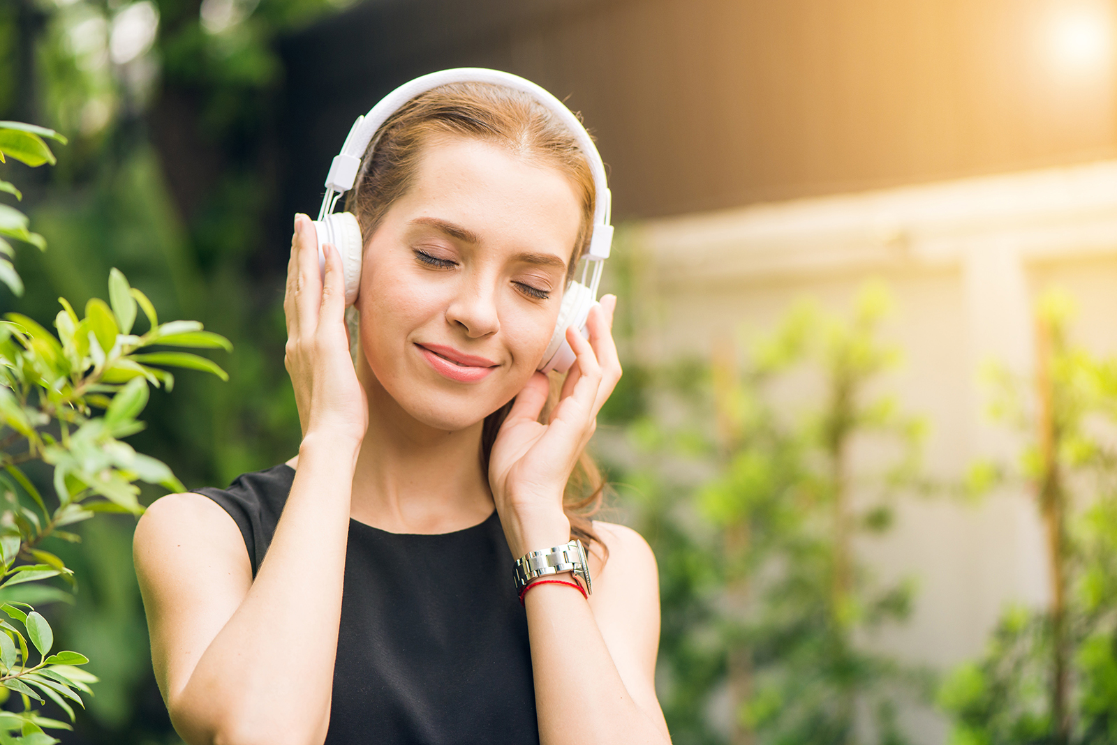 A woman with her eyes closed and earphones on enjoying what she is listening to. Photo: Pexels/Tirachard Kumtanom