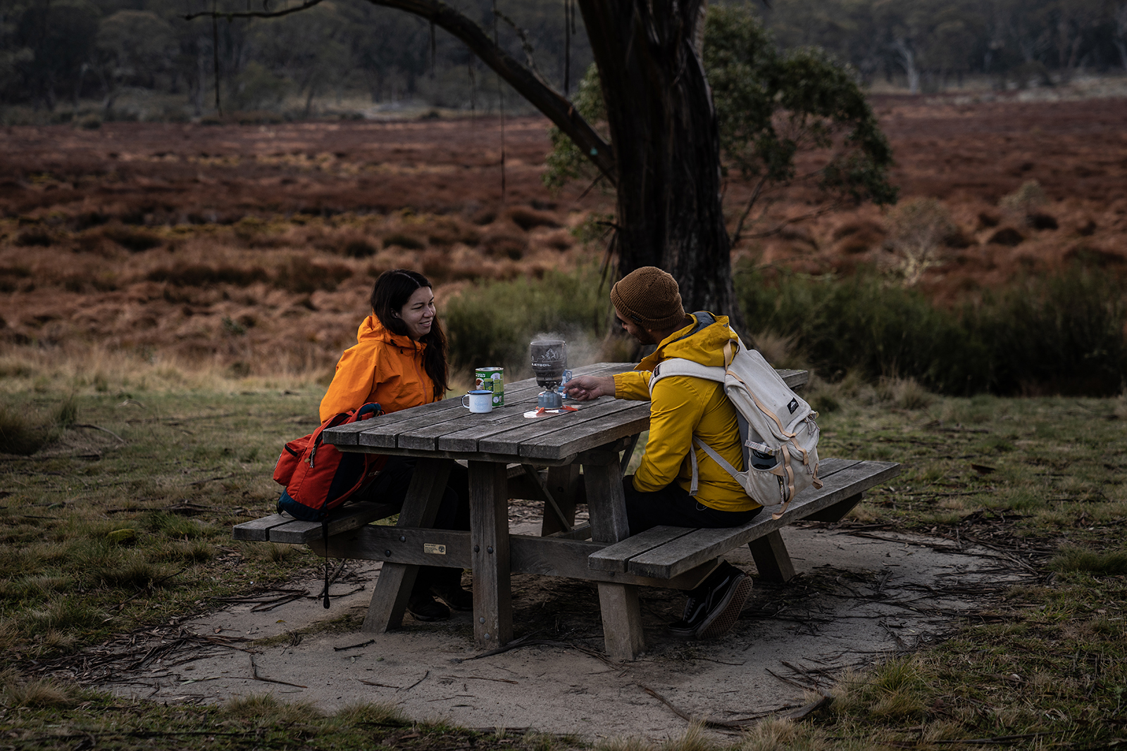 Two people enjoying a hot drink on a picnic bench in Barrington Tops National Park. Photo credit: Rob Mulally/DPIE