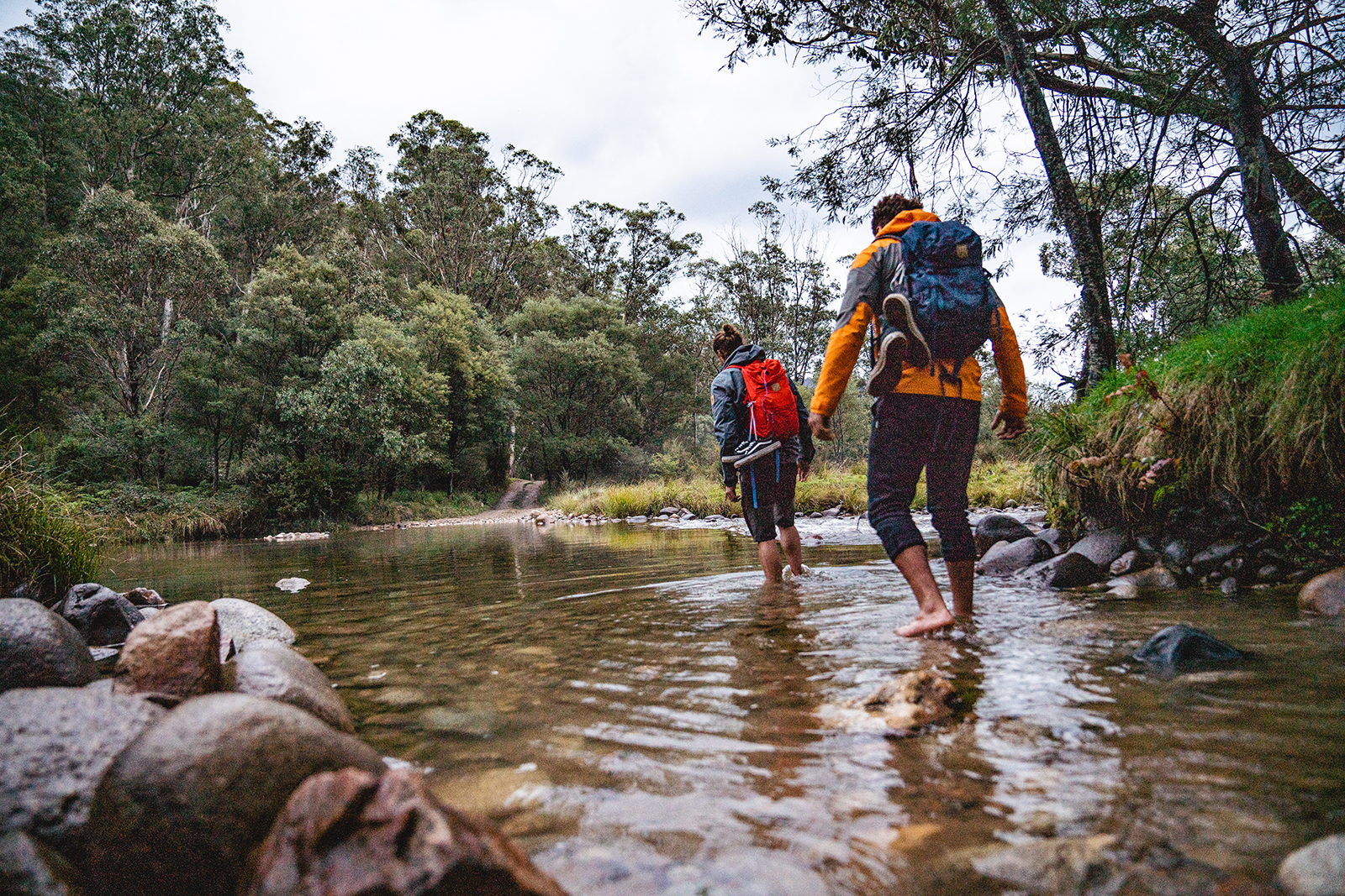 Two people crossing the Swampy Plains River in Kosciuszko National Park. Photo credit: Rob Mulally/DPIE