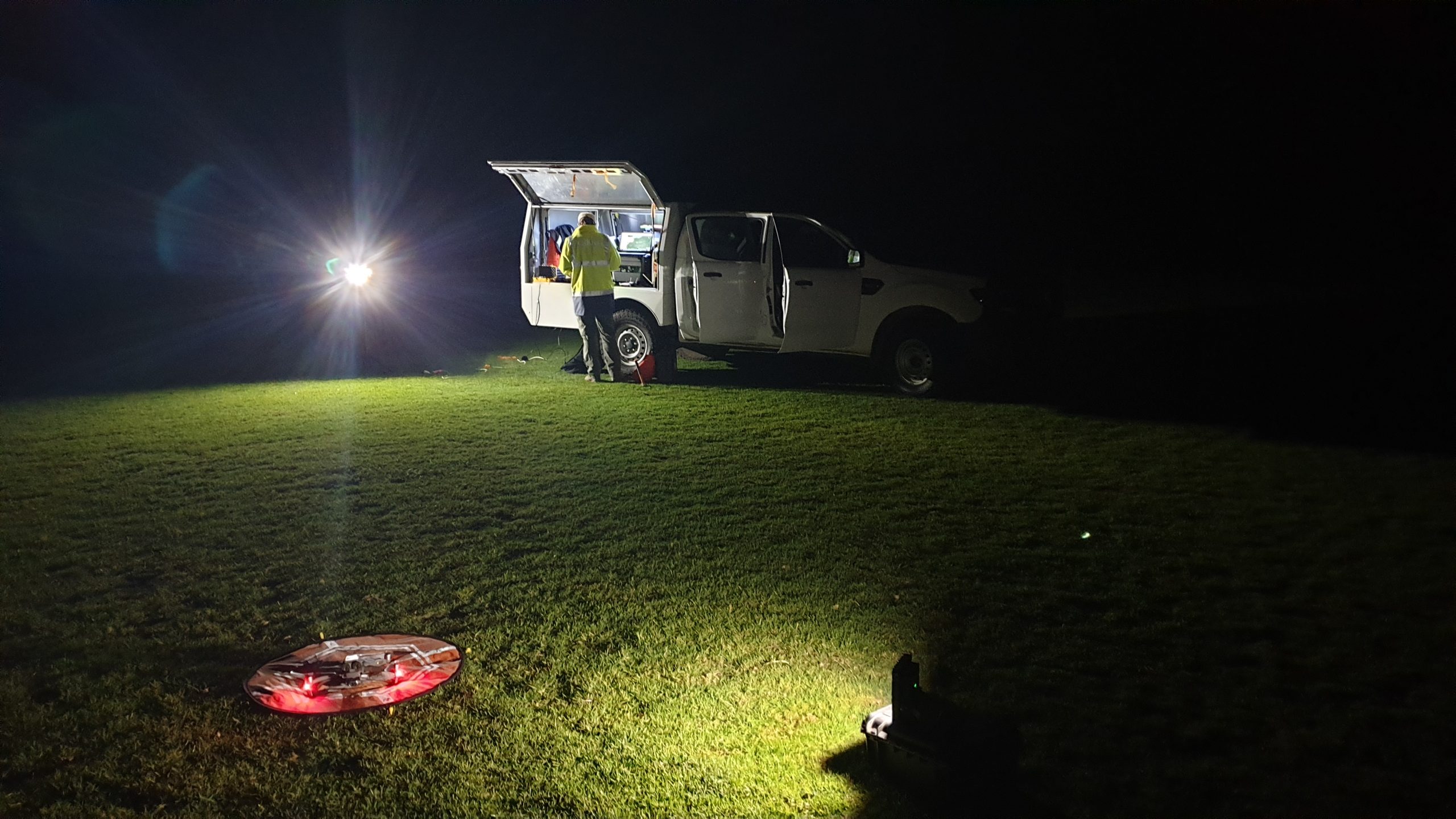 NSW National Parks Drone pilot setting up a drone under light from his vehicle at night. Photo: Scott Colefax / DCCEEW  © Scott Colefax