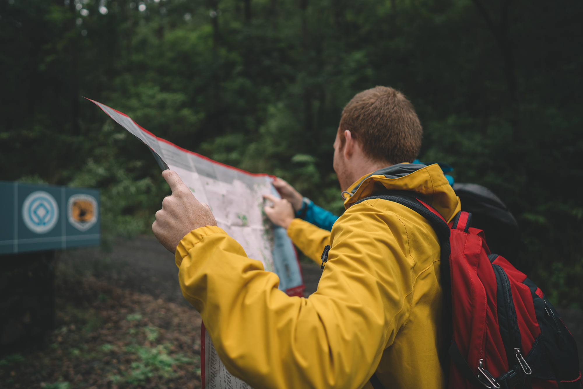A man checking a paper map in a NSW national park. Photo credit : Branden Bodman / DPIE