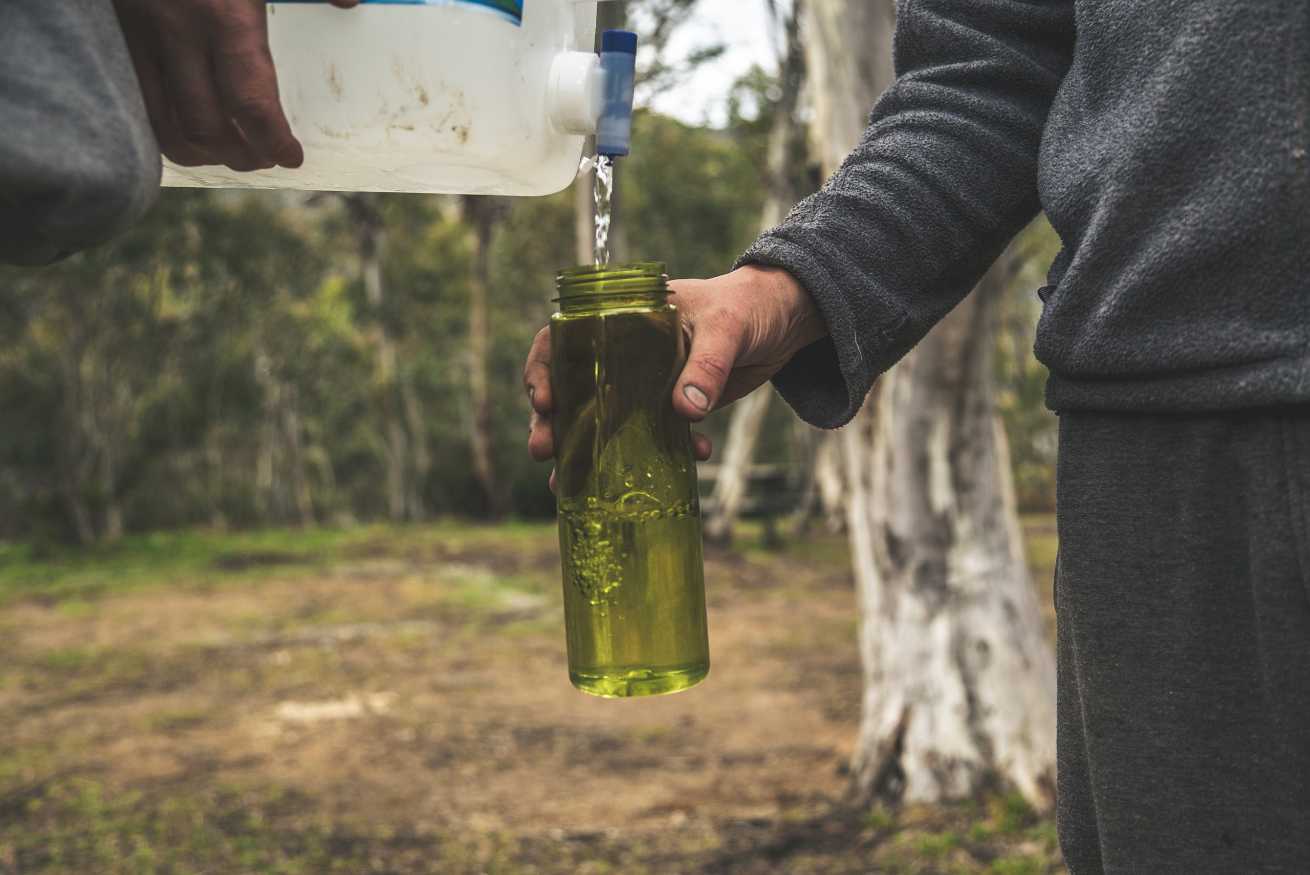 Filling up a drink bottle with water from a large container . Photo credit: Dan Parsons / DPIE