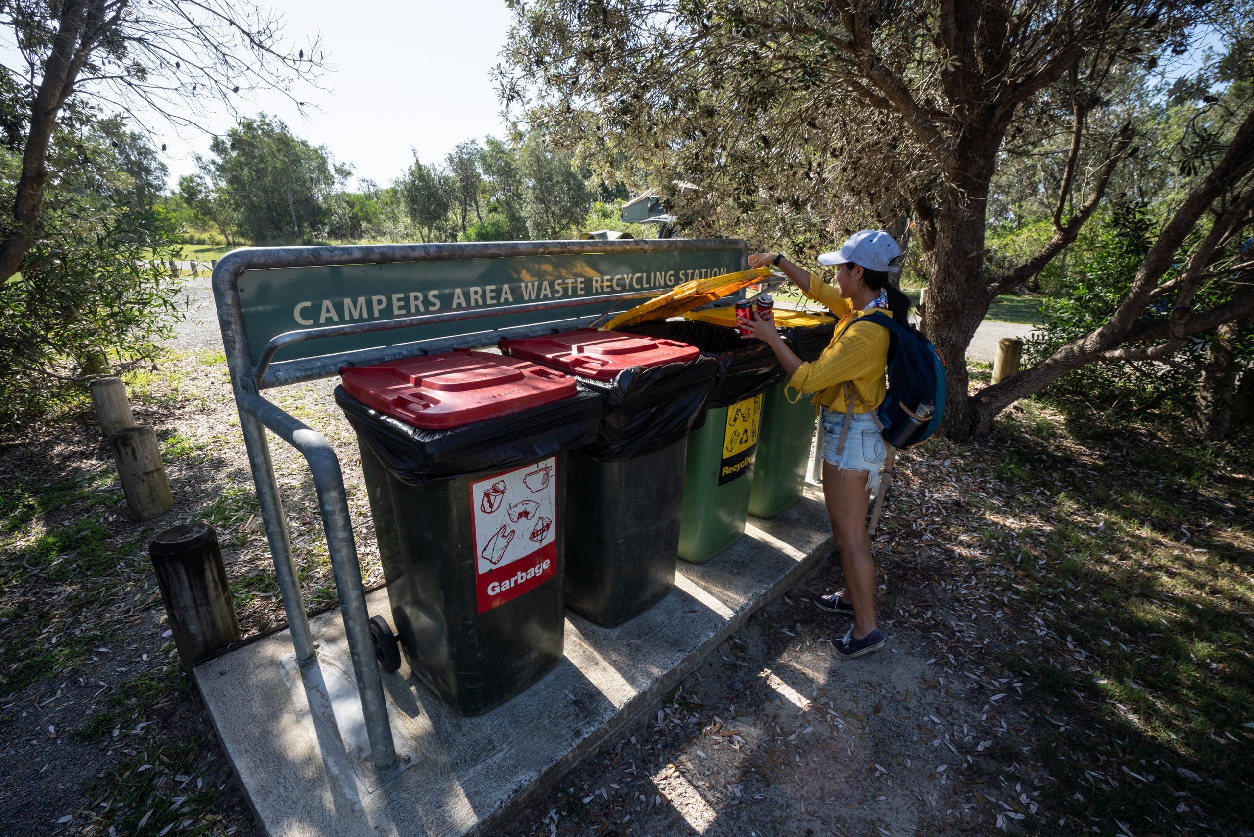 A person throwing away rubbish in the bins in a NSW National Park. Photo credit: Rob Mulally / DPIE