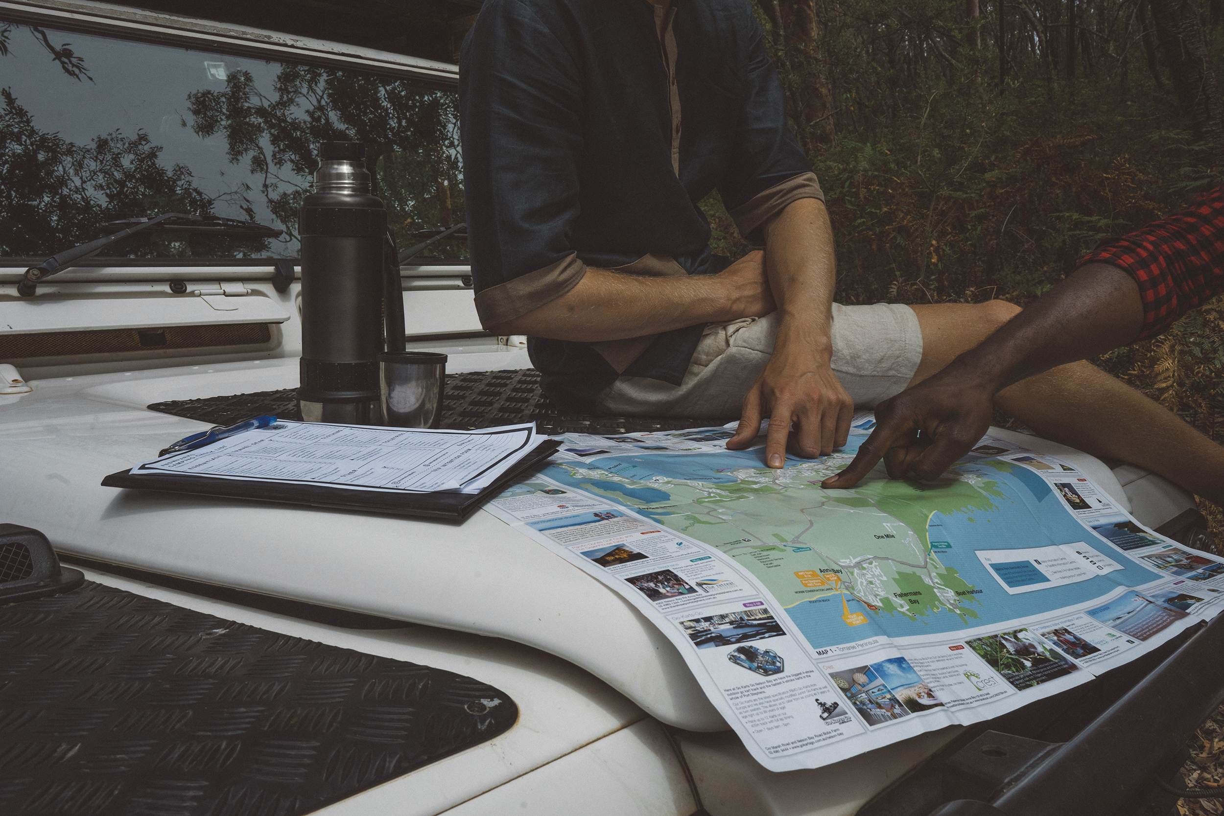 Two people on the dash of their car looking at a map. Photo credit : Erin McGauley