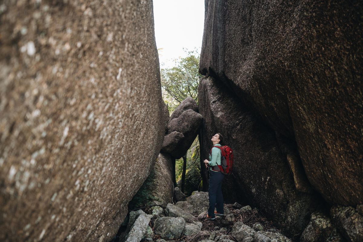 Standing in a rocky chasm at Woollool Woolloolni Aboriginal Place. Photo credit: Harrison Candlin / DPE