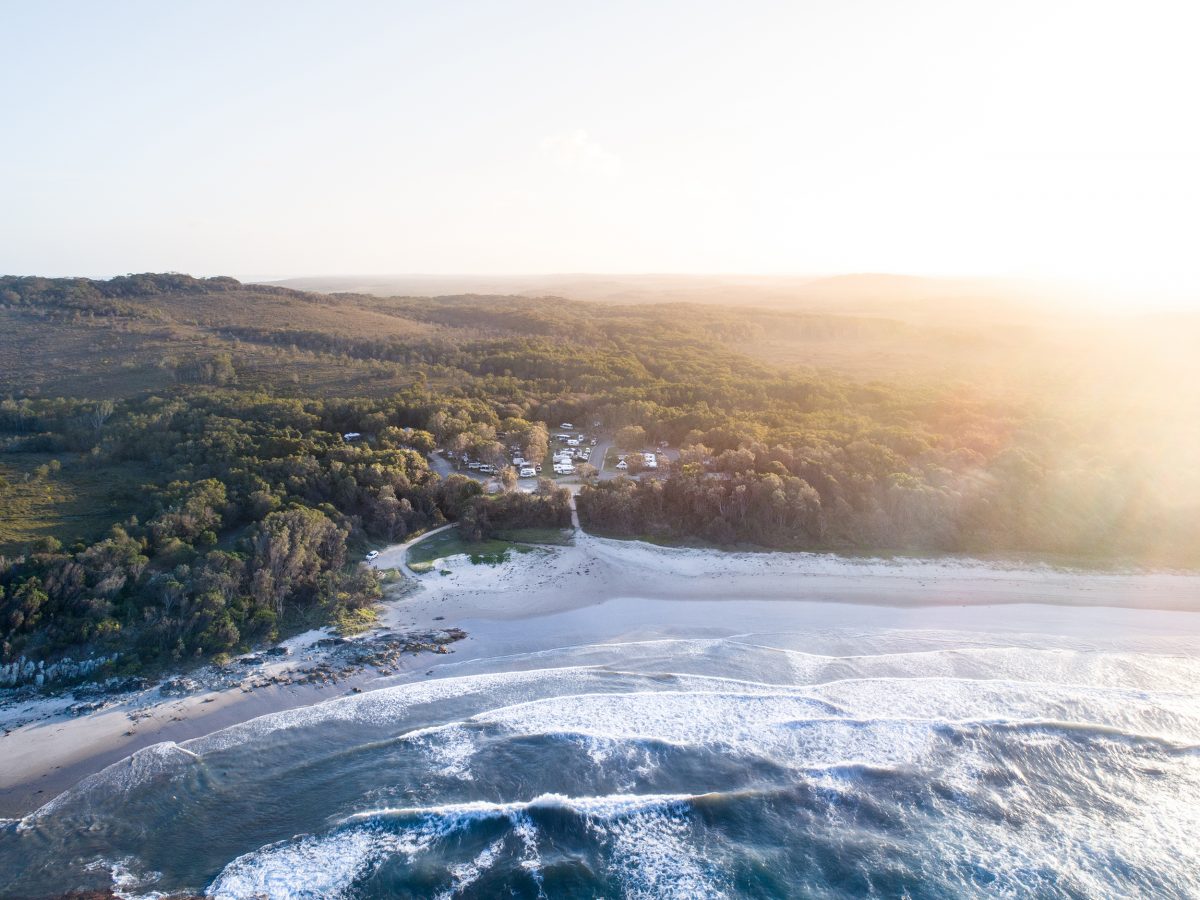 Aerial view of Diamond Head campground and the coast at sunset, Crowdy Bay National Park. Photo credit: Rob Mulally / DCCEEW © Studio Bilby