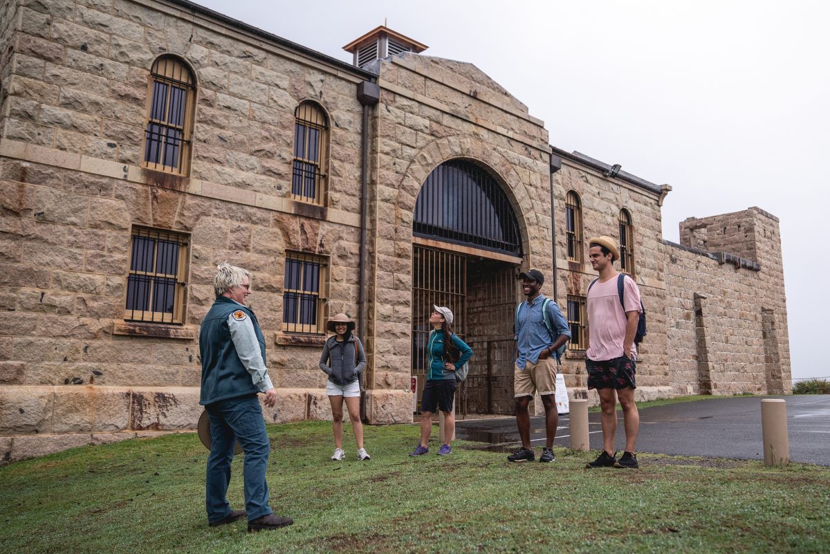 Four people on a tour outside Trial Bay Goal, Arakoon National Park. Photo: credit: Rob Mulally / DCCEEW © Studio Bilby