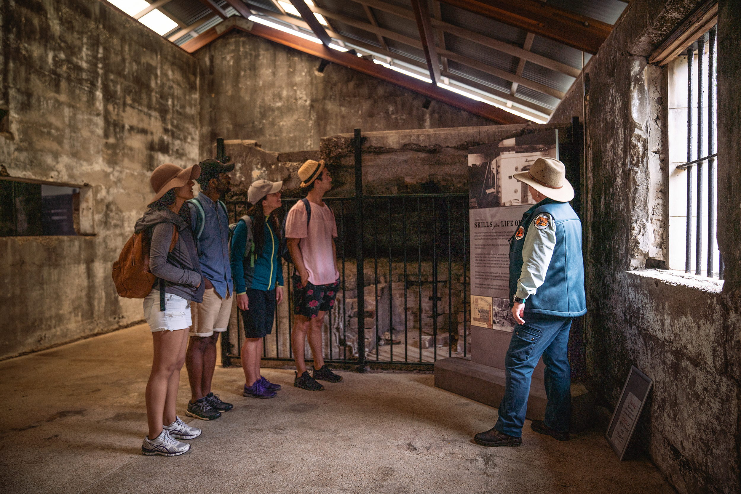 Four people on a guided Trial Bay Gaol tour, Arakoon National Park. Photo: Rob Mulally / DCCEEW © Studio Bilby