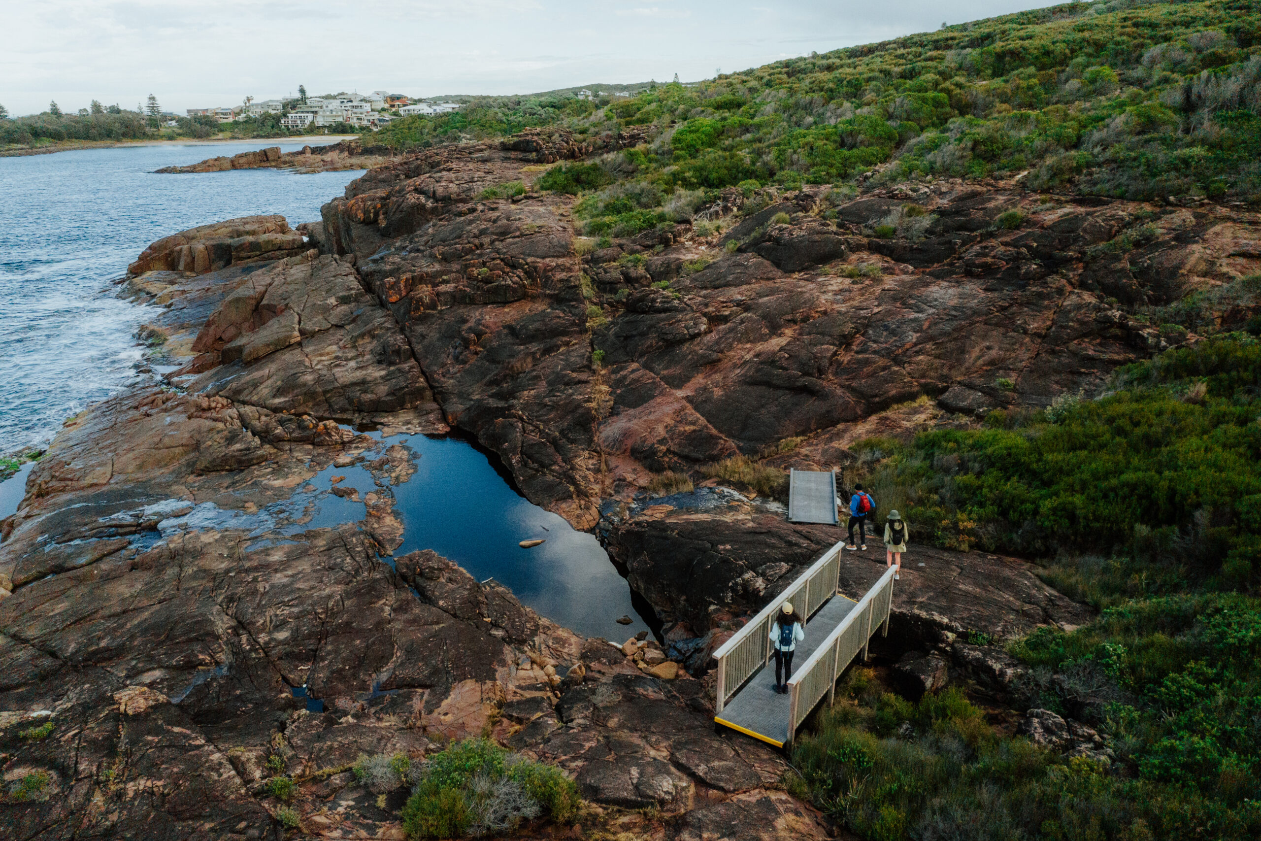 3 people walking along Tomaree Coastal Walk, Boat Harbour, Tomaree National park. Photo: Remy Brand / DCCEEW © Studio Bilby