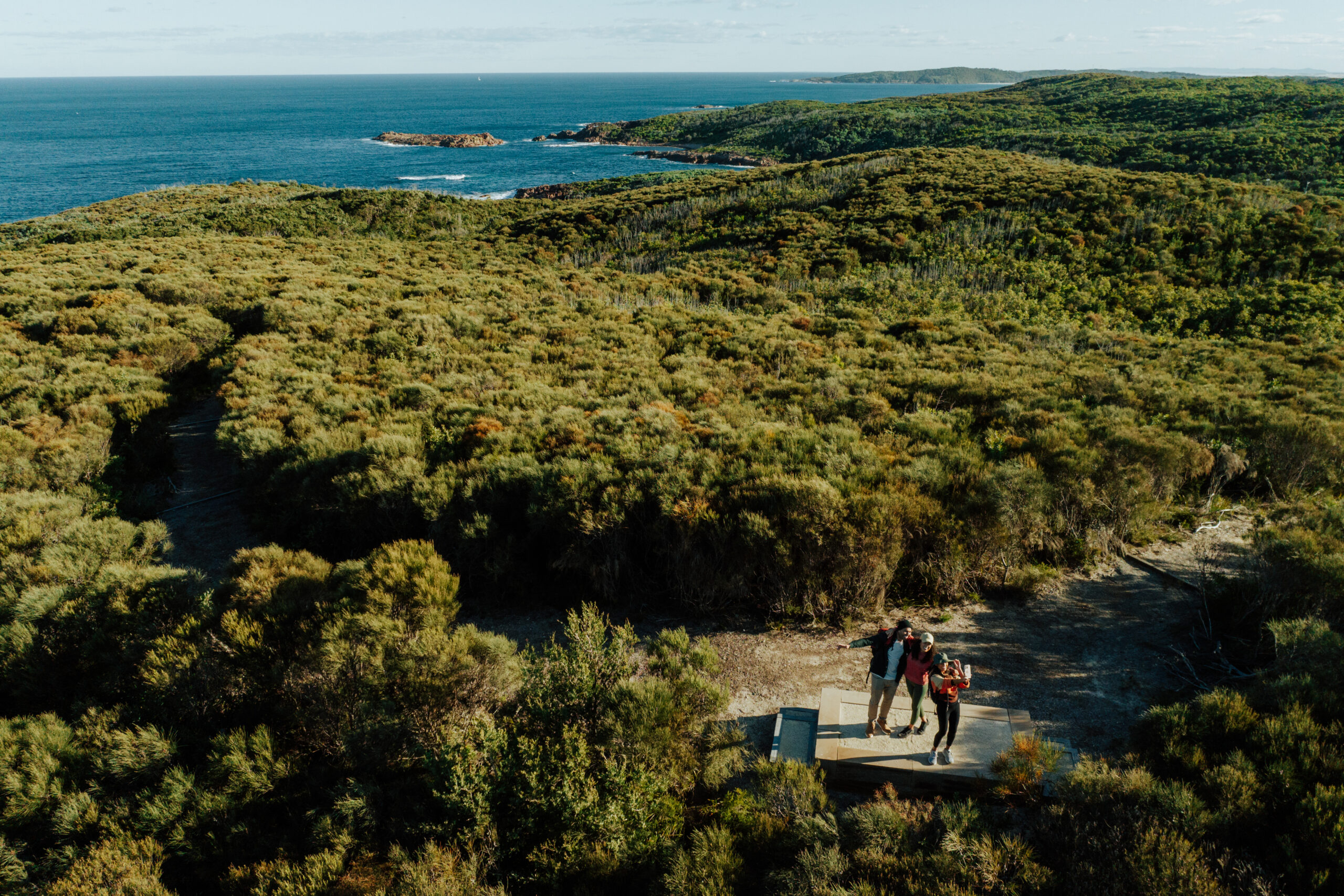 Three people walking Tomaree coastal walk, Tomaree National Park. Photo: Remy Brand / DCCEEW © Studio Bilby