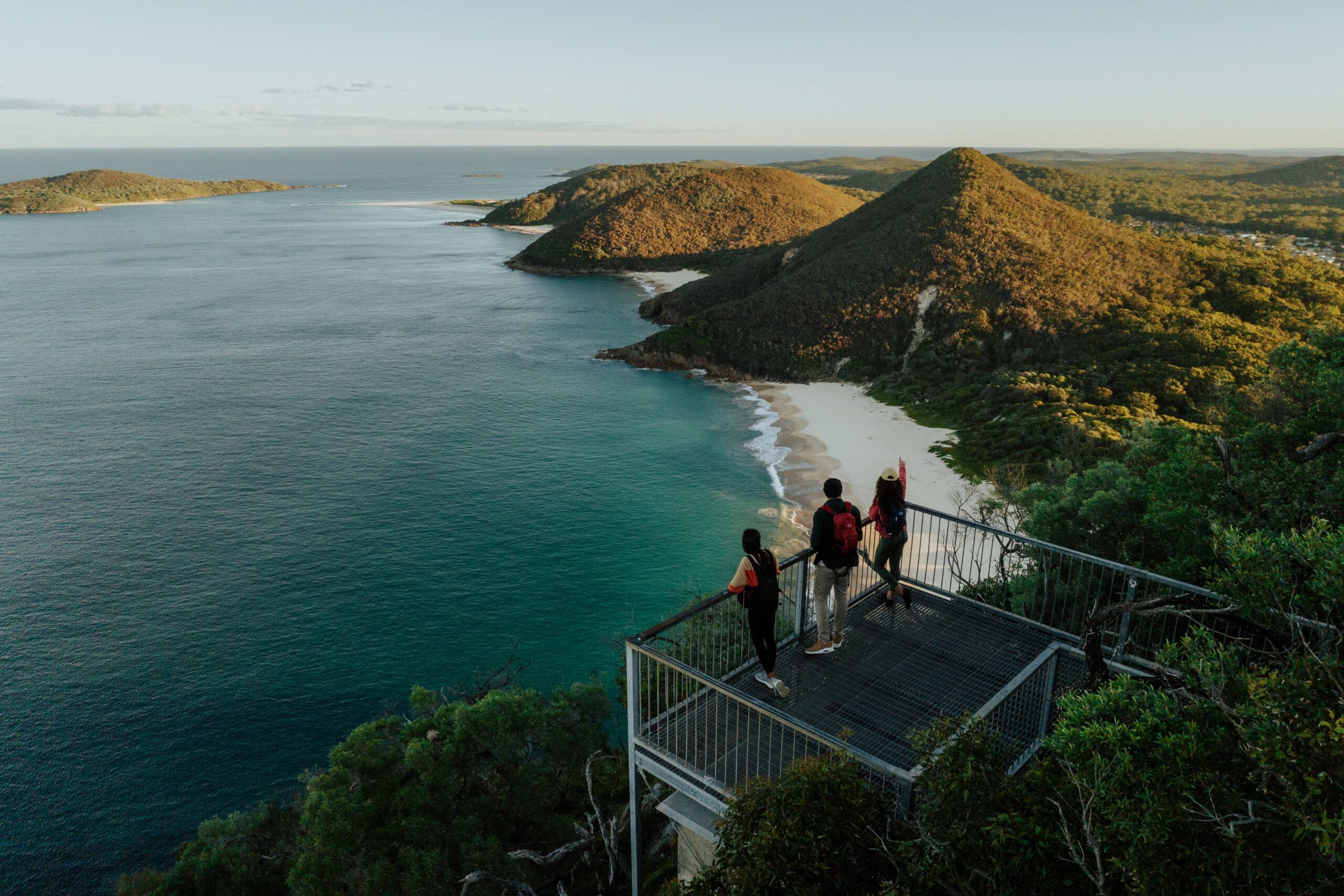 Three people at Tomaree Head Summit. Tomaree Coastal Walk, Tomaree National Park. Photo: Remy Brand / DCCEEW © Studio Bilby