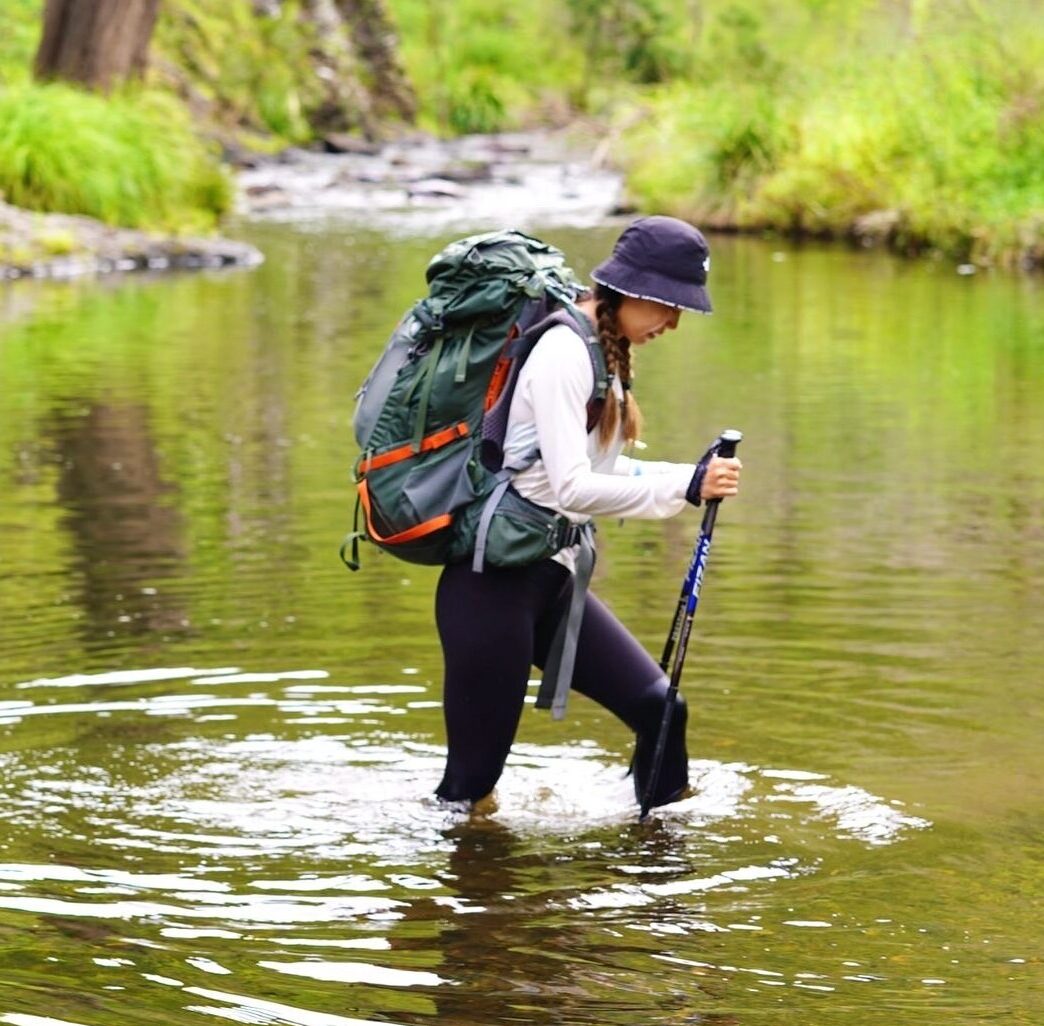 Woman crossing river, Green Gully track, Oxley Wild Rivers National Park. Photo credit: Sue Kang / DPE