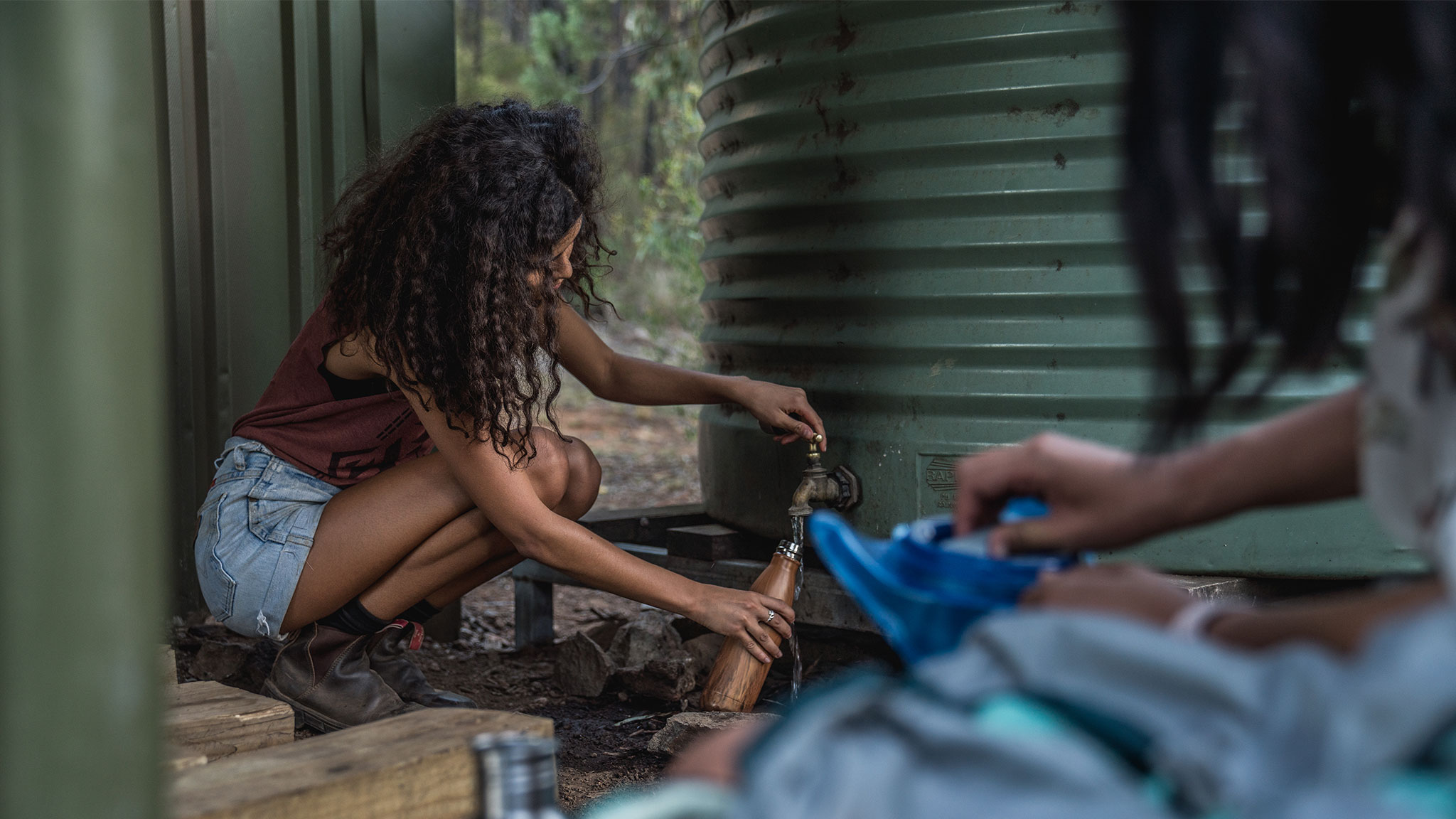 Woman filling up water bottle, Warrumbungle National Park. Photo credit: Rob Mulally / DPE