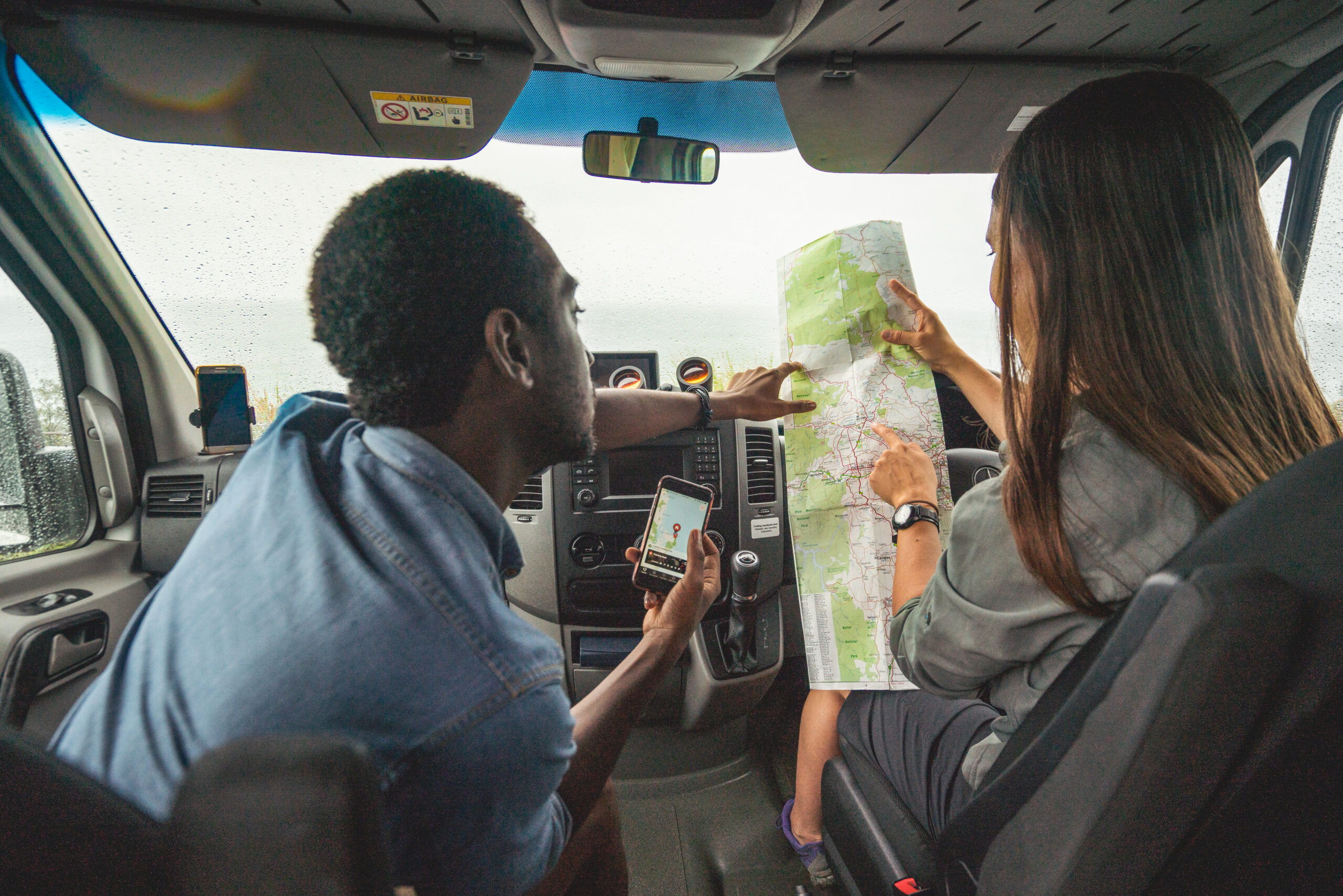 Couple reviewing map in a car, Arakoon National Park. Photo credit: Rob Mulally / DPE