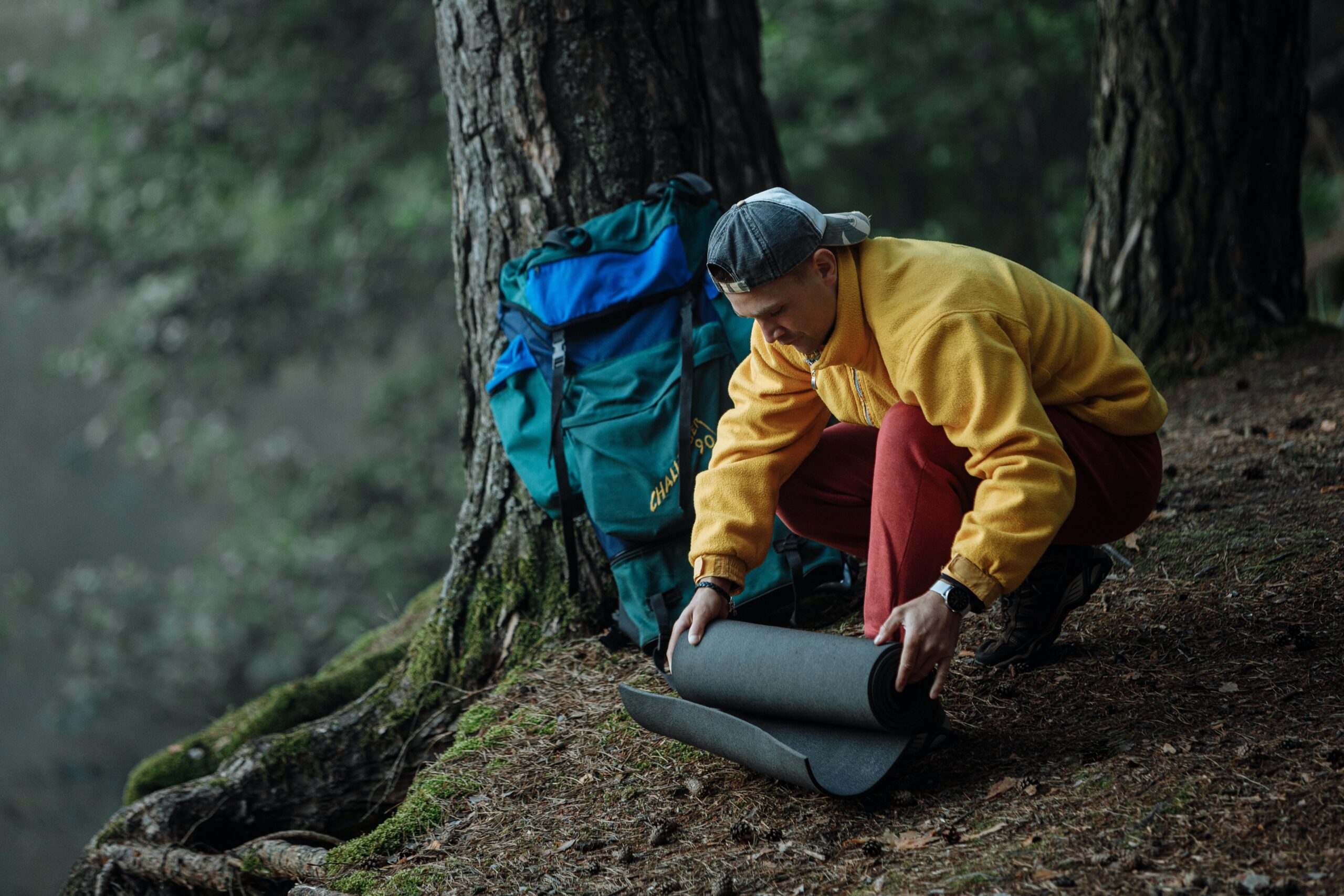 Man unrolling sleeping mat. Photo: Thirdman via Pexels