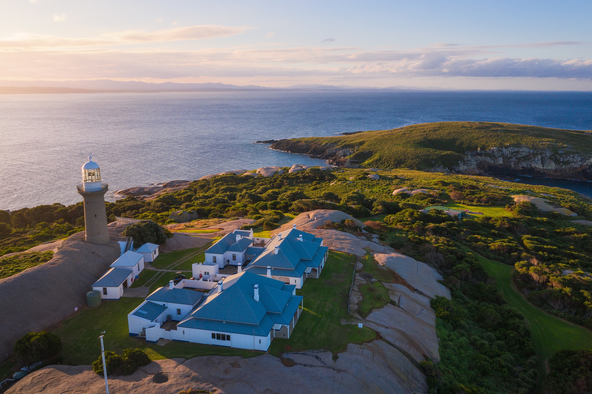Montague Island Lighthouse perched on the rocky coastline of Barunguba Montague Island. Photo credit: Daniel Tran/DCCEEW