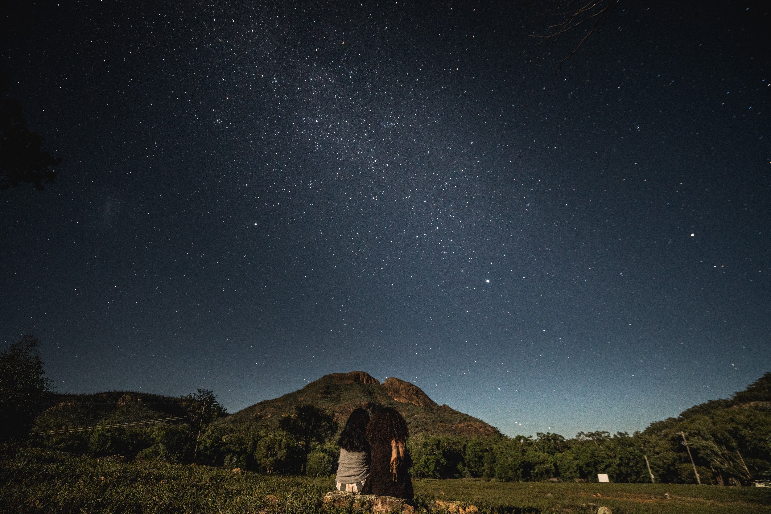 Two campers amdire the starry night sky in Warrumbungle National Park. Photo credit: Rob Mulally/DCCEEW