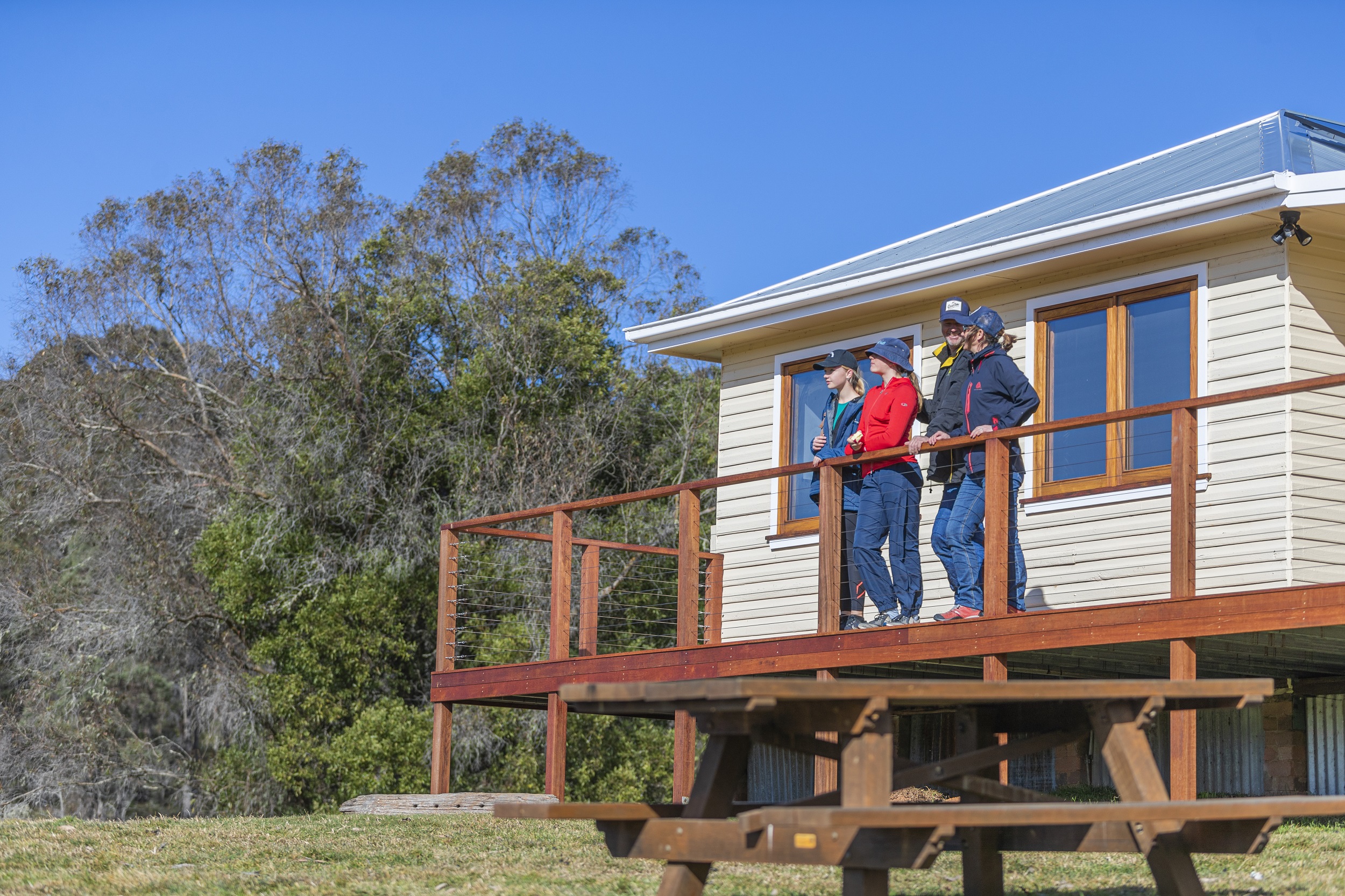 Family on the deck outside Mooraback Cabin. Photo credit: Josh Smith/DCCEEW