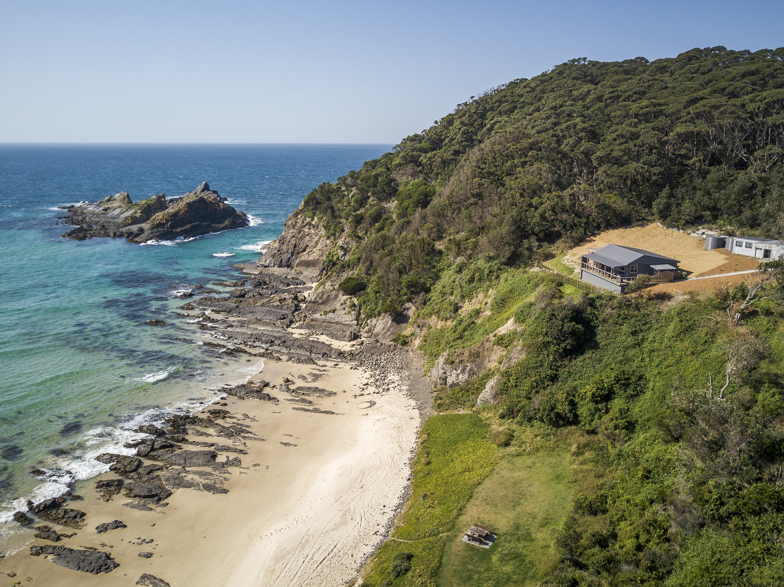 Davies Cottage perched on the cliff edge. Photo credit: Brent Mail/DCCEEW