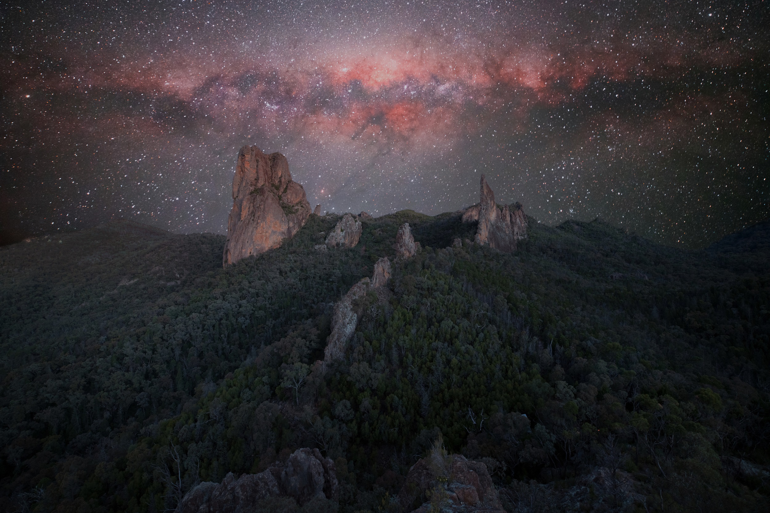 The colourful night sky above the rocky peaks of the Warrumbungles. Photo creidt: Ben Heaton/DCCEEW