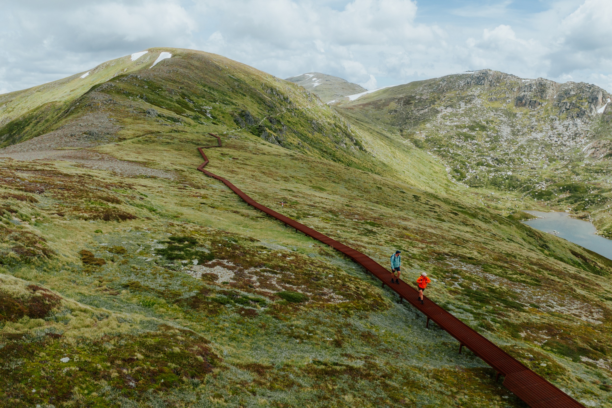 Two walkers on the Main Range walk section of the Snowies Alpine Walk. Photo credit: Daniel Parsons/DCCEEW © Studio Bilby