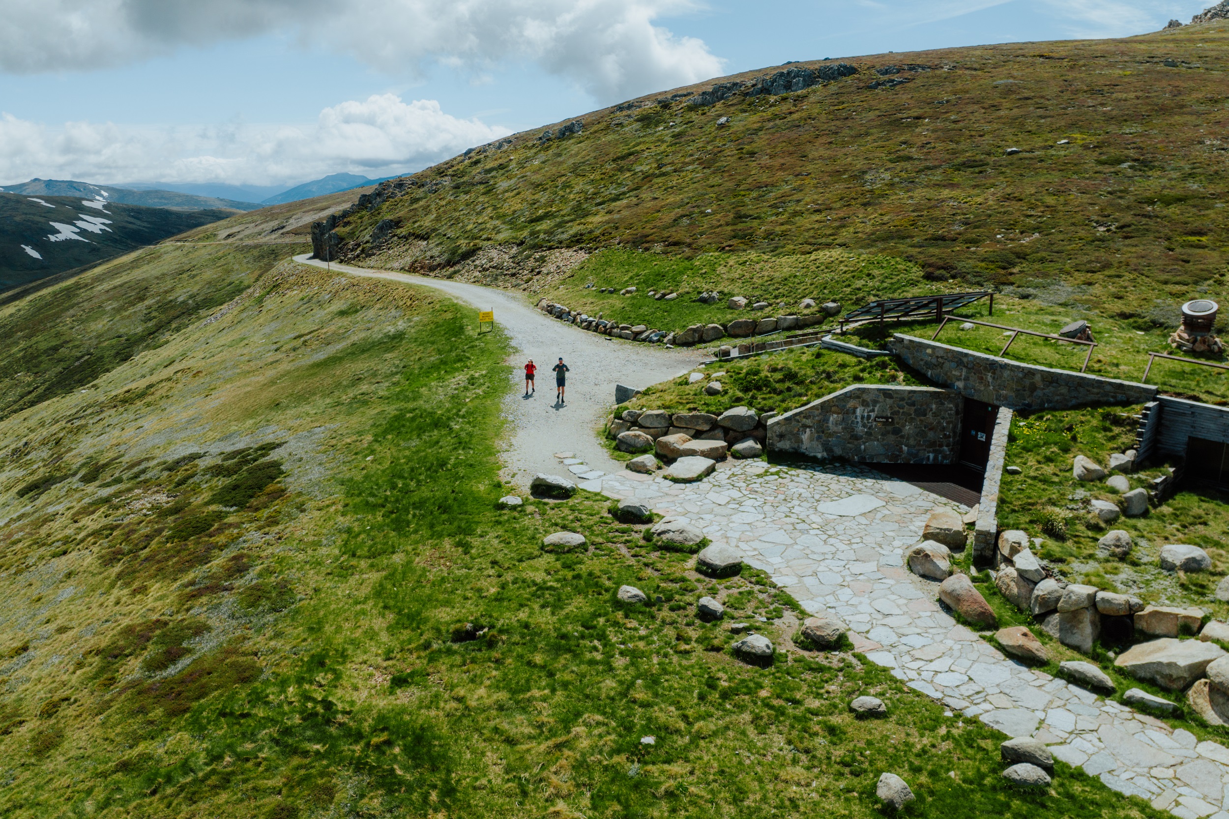 Two people walking on the Rawsons Pass section of the Snowies Alpine Walk. Photo credit: Daniel Parsons/DCCEEW © Studio Bilby