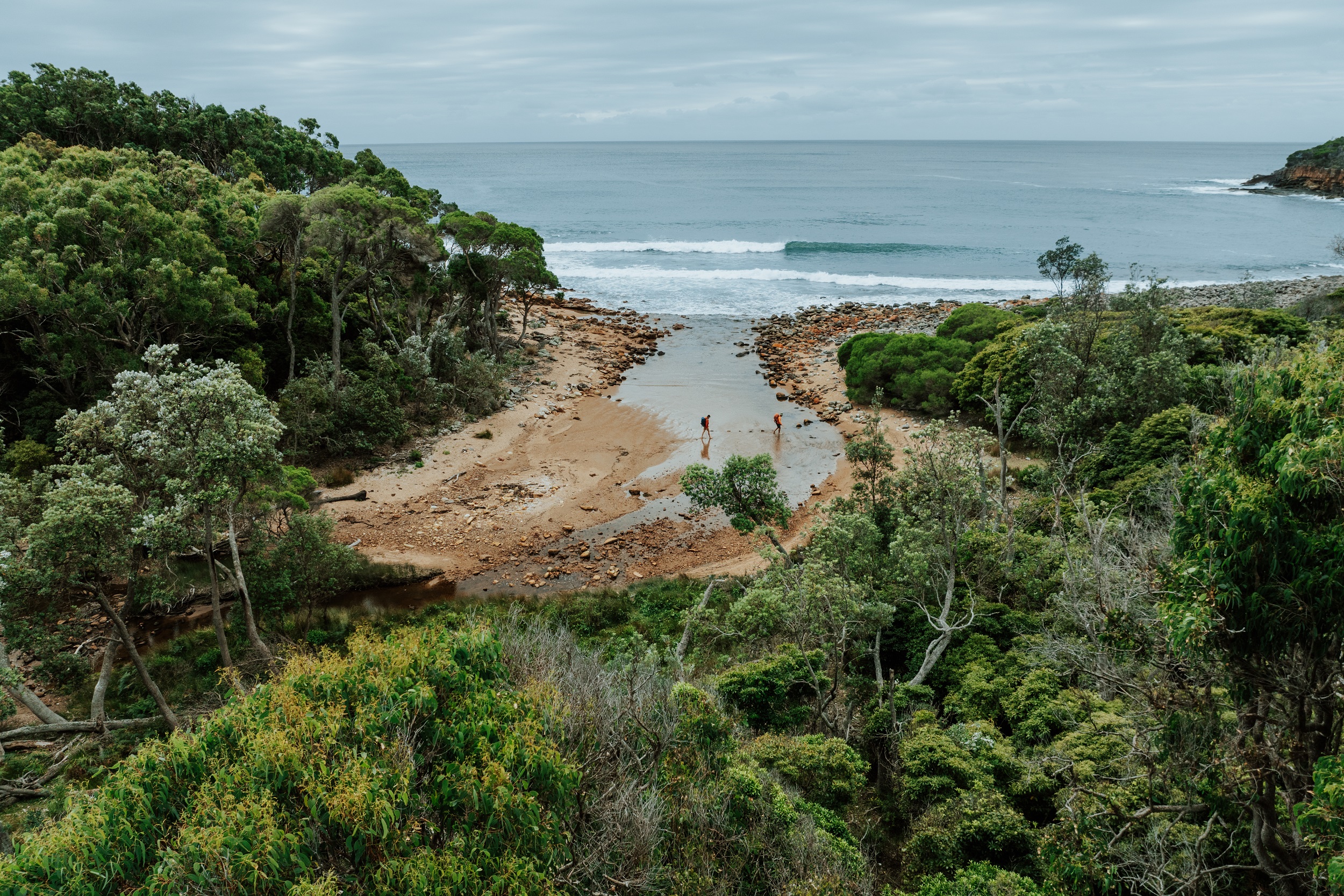 Two walkers at Leather Jacket Bay on the Light to Light Walk. Photo credit: Daniel Parsons/DCCEEW © Studio Bilby