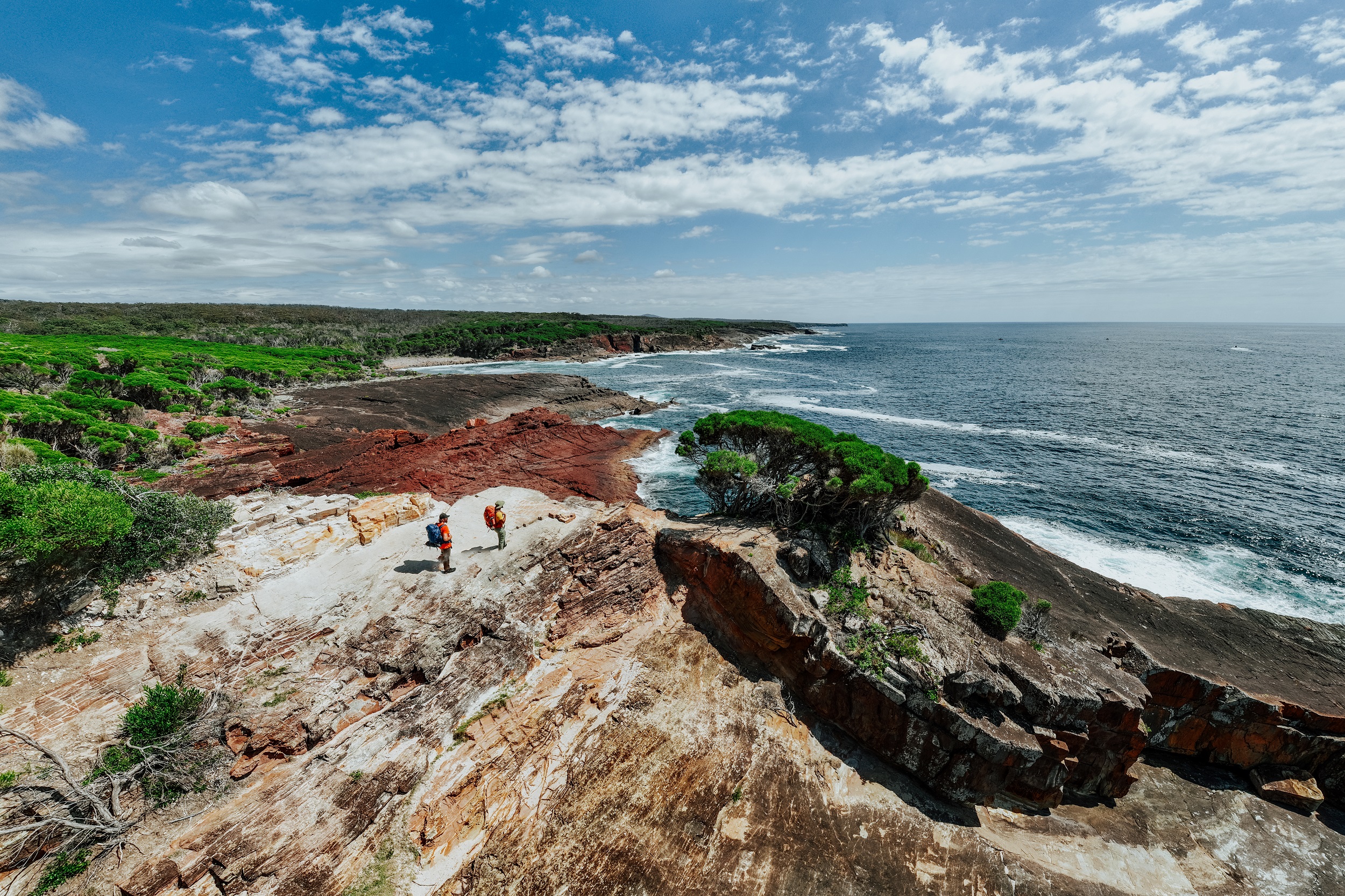 Two walkers take in the view from Pulpit Rock on the Light to Light Walk. Photo credit: Daniel Parsons/DCCEEW © Studio Bilby