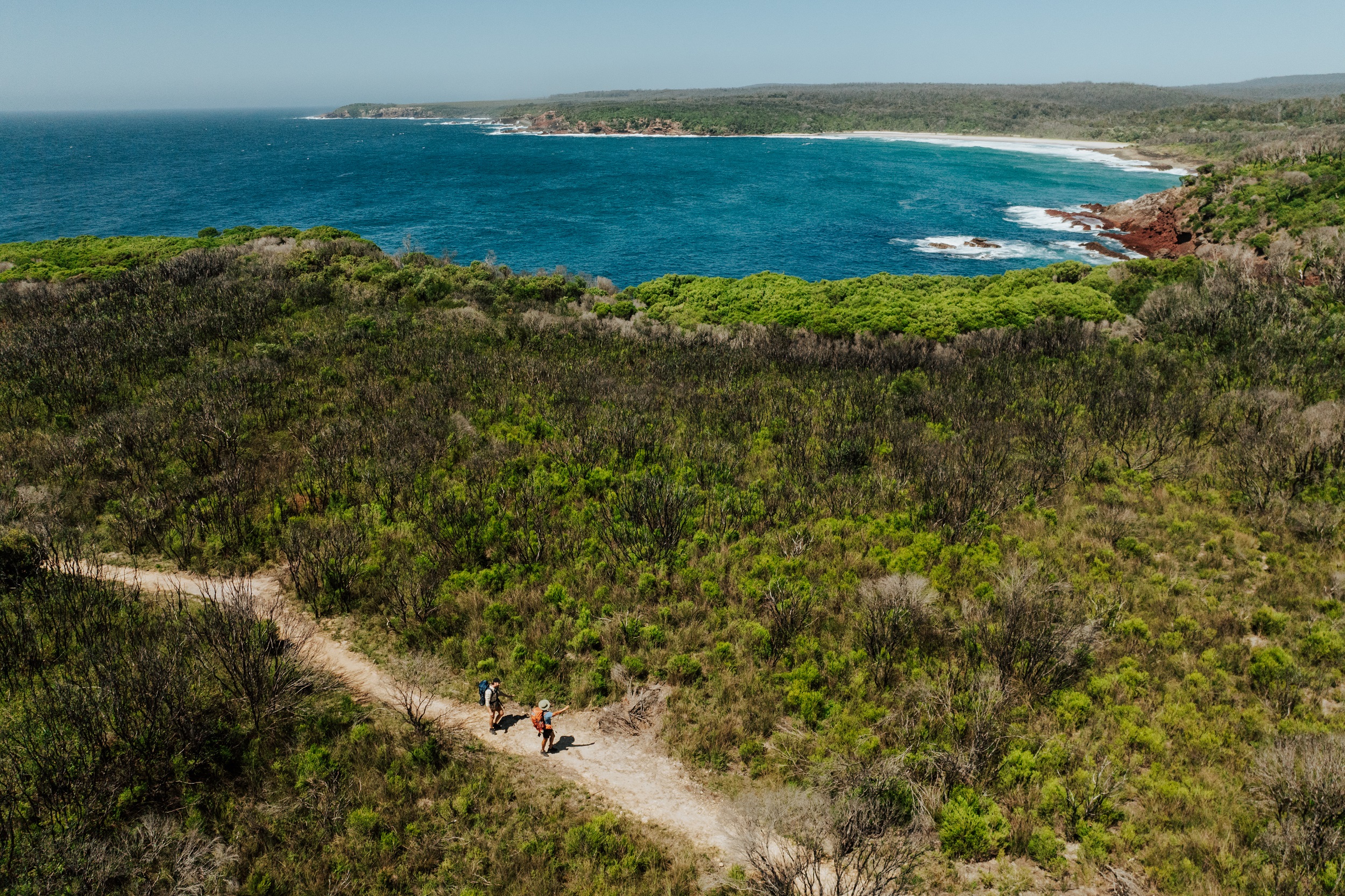 Two walkers at Saltwater Creek on the Light to Light Walk. Photo credit: Daniel Parsons/DCCEEW © Studio Bilby