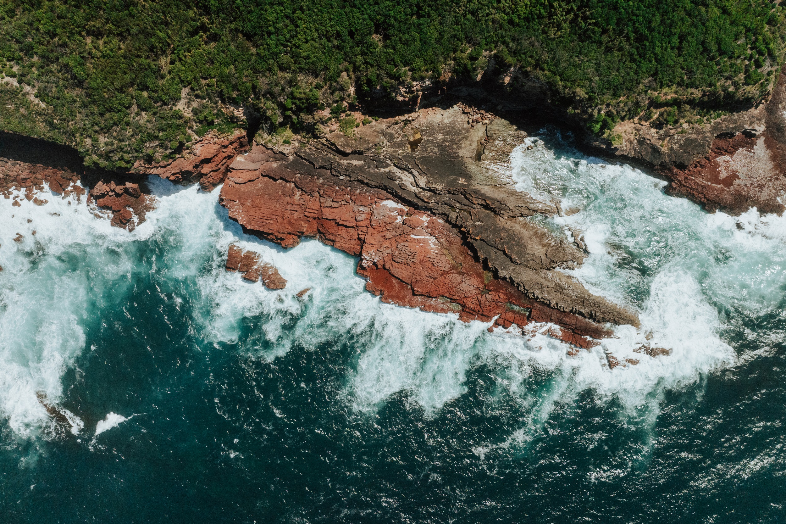 An aerial view of red rock cliffs at Saltwater Creek on the Light to Light Walk. Photo credit: Daniel Parsons/DCCEEW © Studio Bilby
