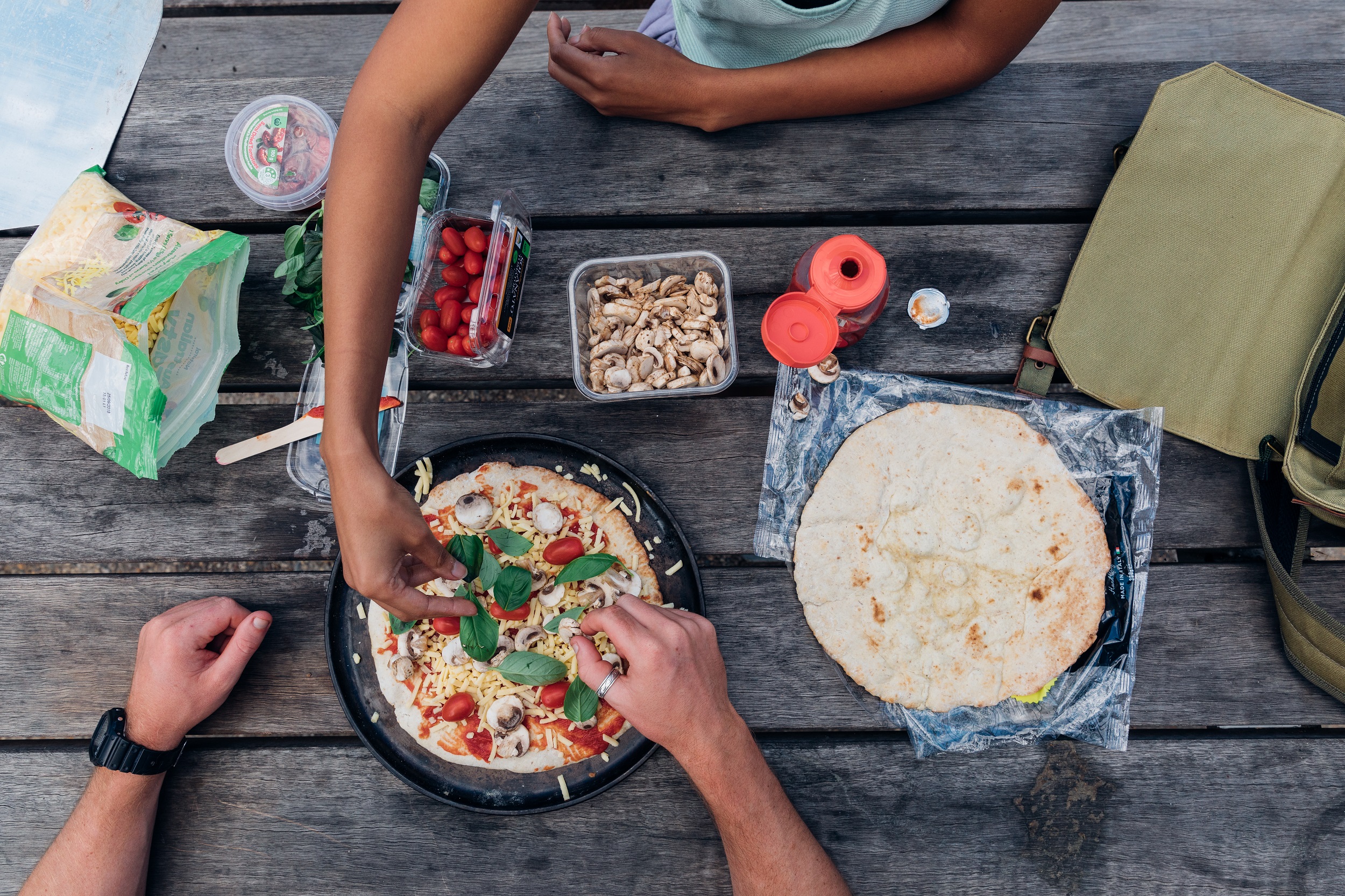 Campers preparing pizzas on a picnic table. Photo credit: Melissa Findley/DCCEEW © Melissa Findley