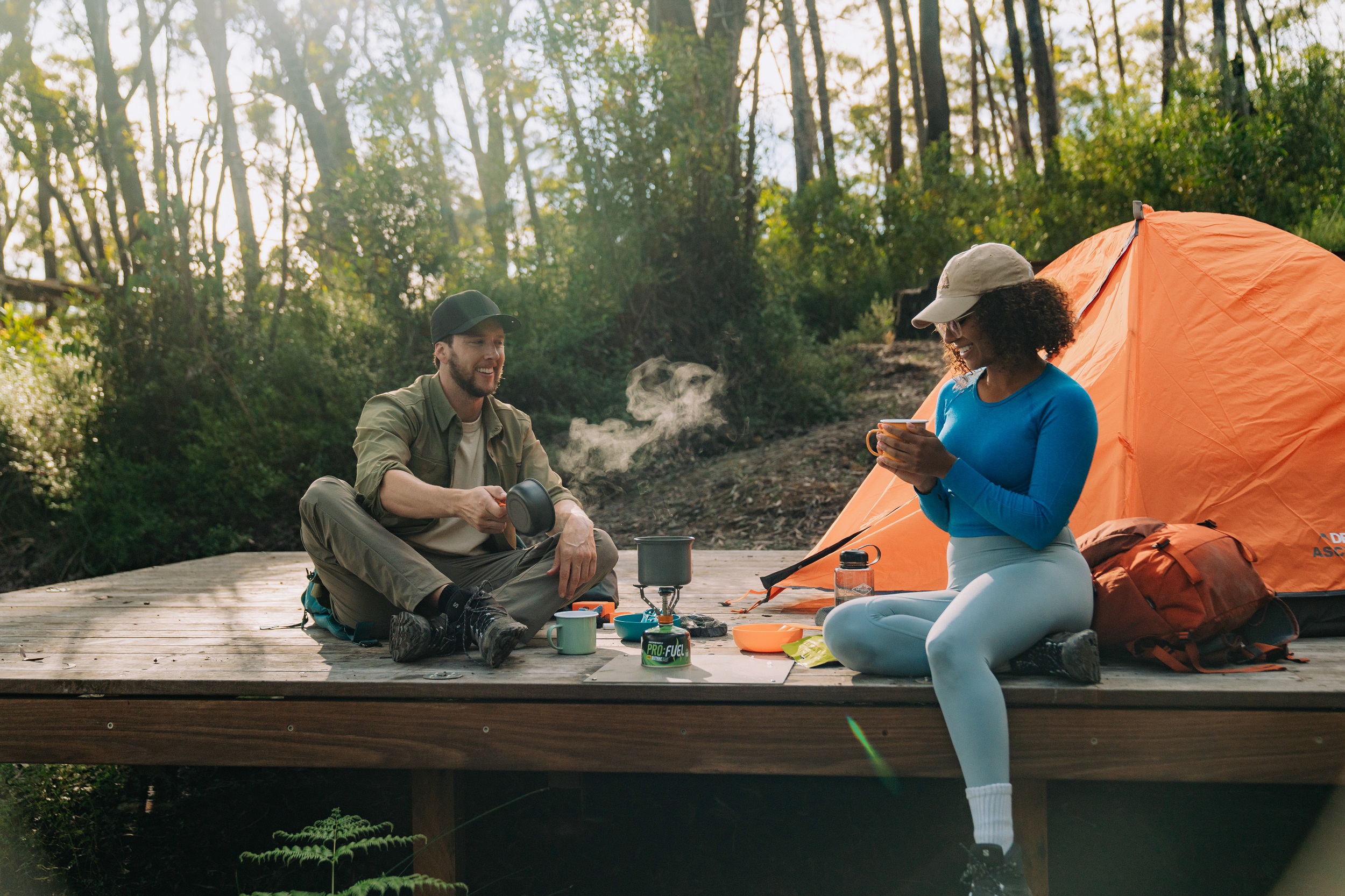 Two walkers enjoy a hot beverage on a camping platform at Yelgun Kyoomgun campground on Gidjuum Gulganyi Walk. Photo: Remy Brand/DCCEEW © Studio Bilby