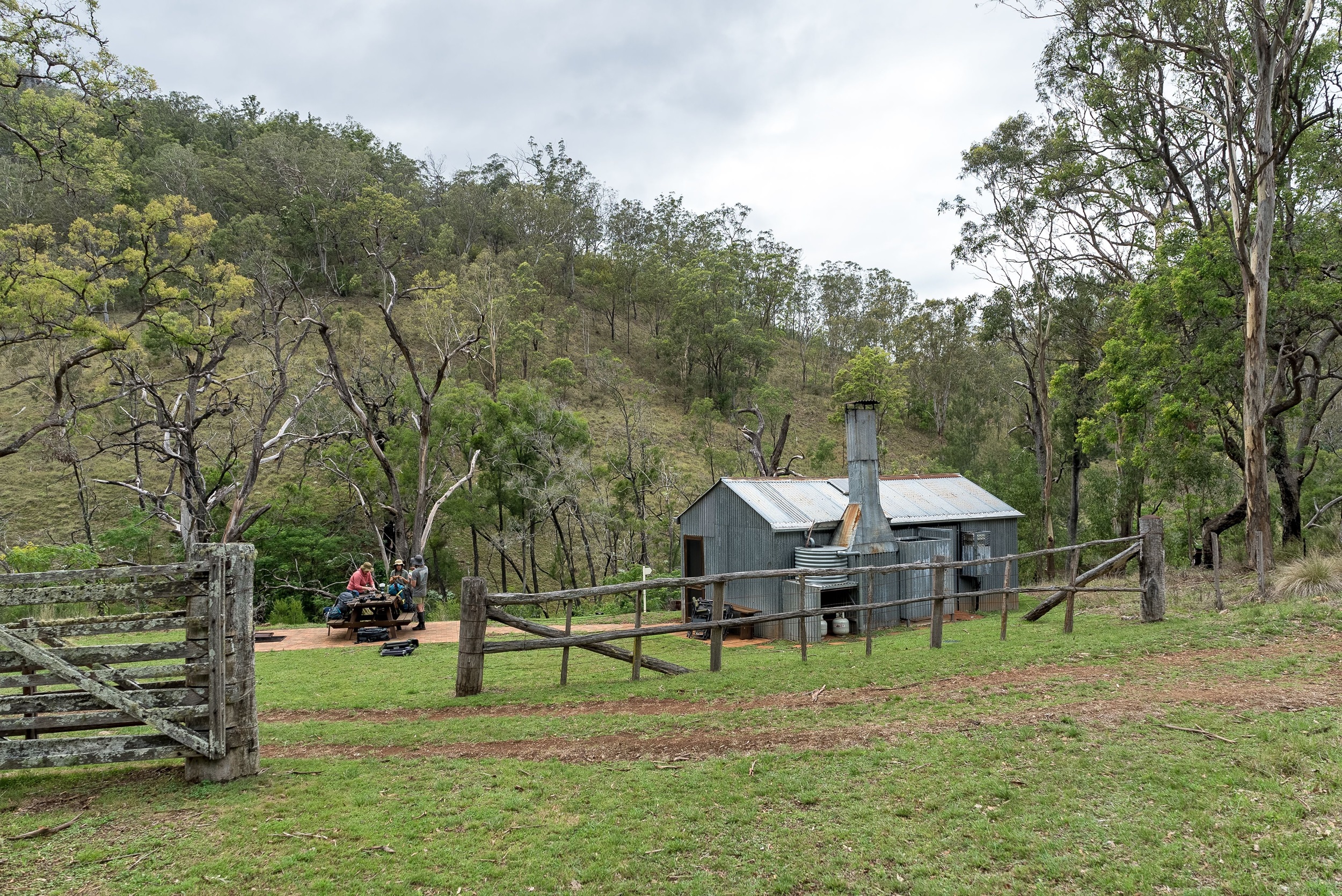 Campers sit outside a hertiage hut on Green Gully Track.