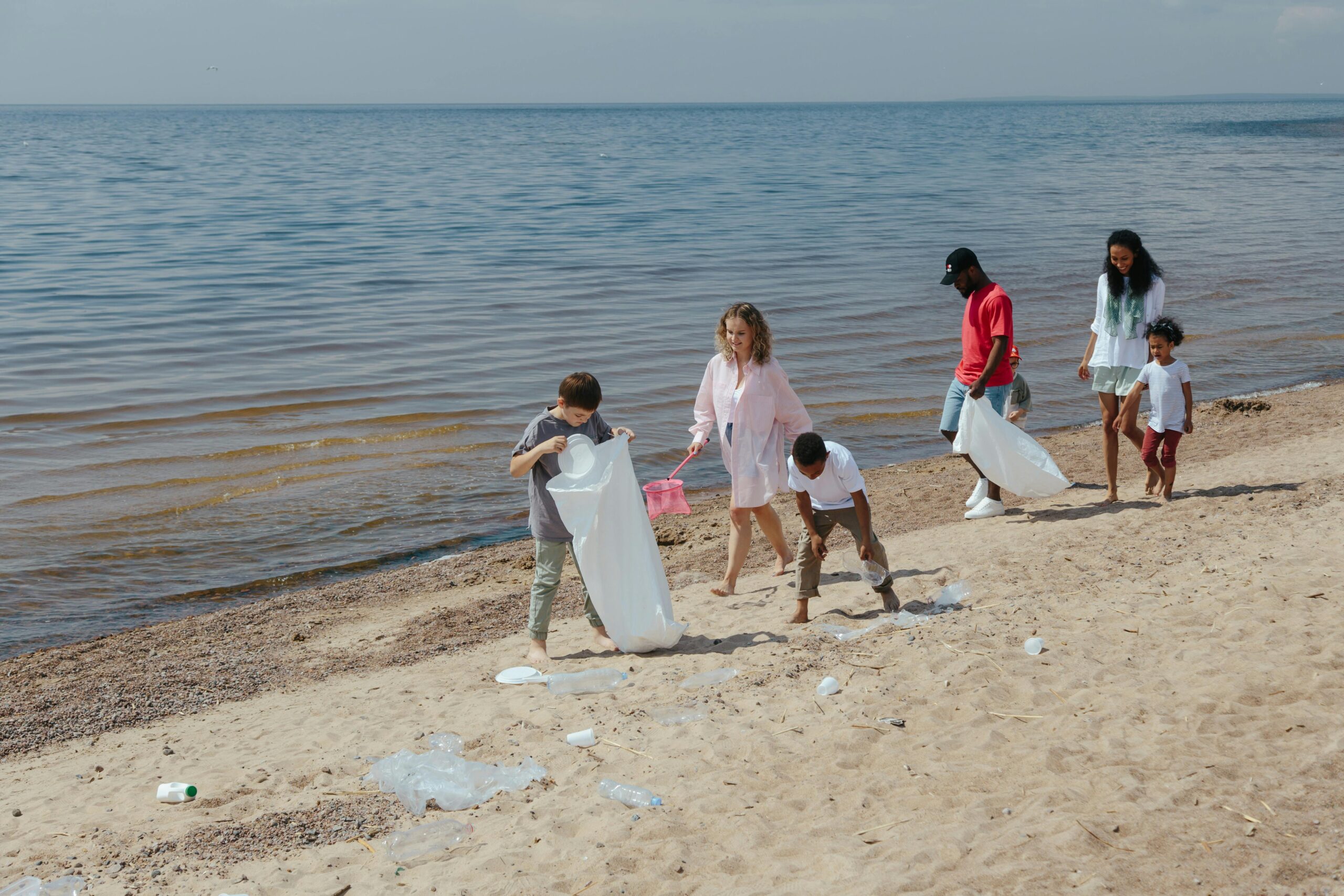 People at the beach pickinh up rubbish. Photo: Ron Lach via Pexels