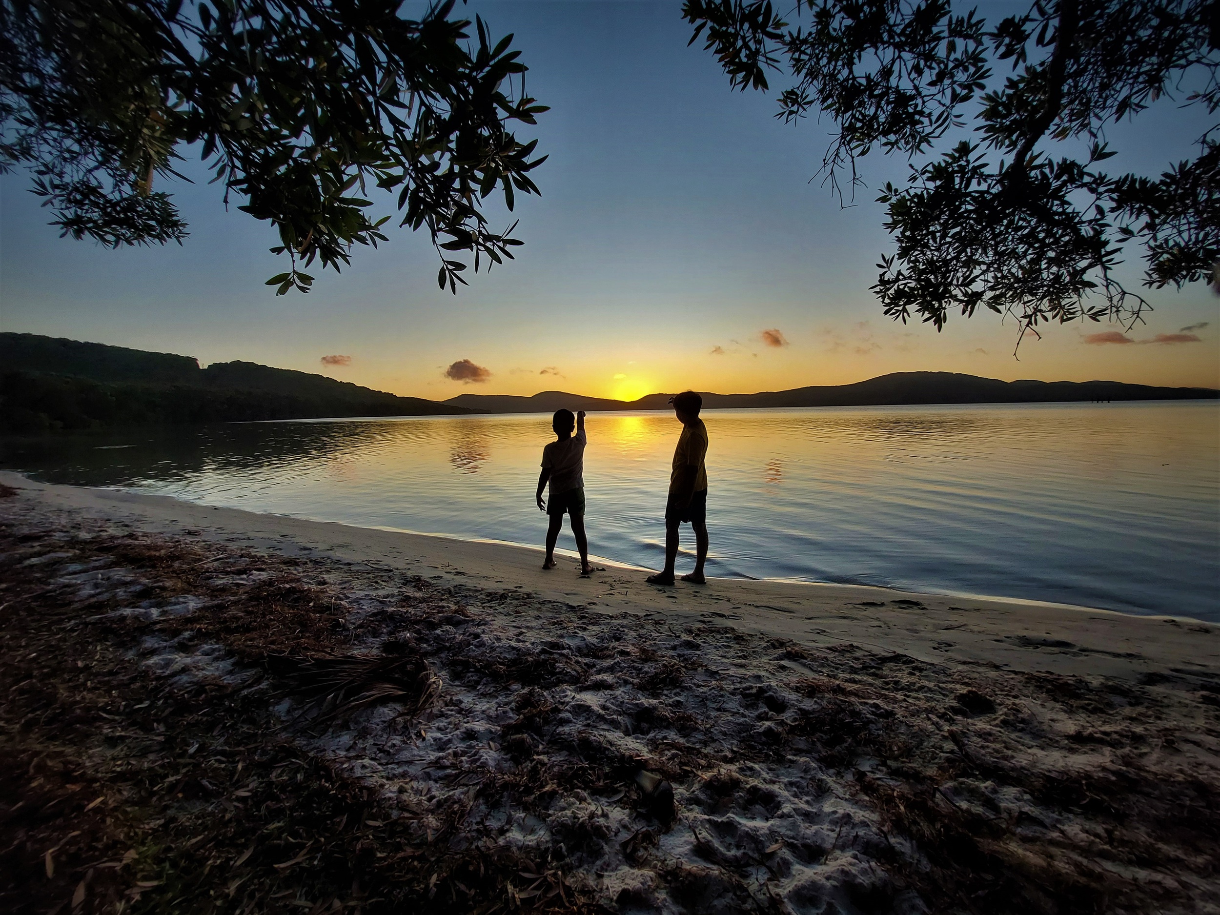Two children on the beach at sunset in Booti Booti National Park