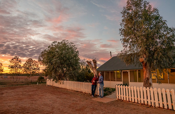 A couple watch the sunset outside Mount Wood Homestead, Sturt National Park. Photo: John Spencer/DPIE