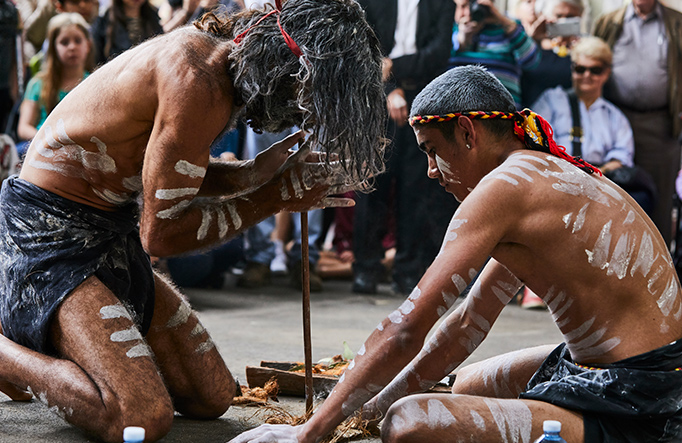 Two men share an Aboriginal cultural technique of fire starting with visitors. Photo credit: Flash Point Labs &copy; Tribal Warrior