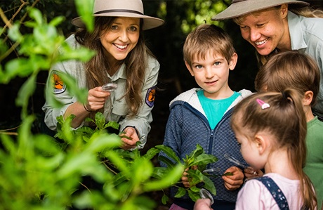 Photo of 2 Discovery Rangers with kids enjoying a tour in the bush. Credit &copy; Louise Walpole/DCCEEW 