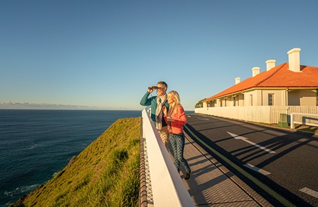 People whale watching from the front of the Assistant Lighthouse Keepers Cottages, Cape Byron State Conservation Area. Photo: John Spencer &copy; DCCEEW