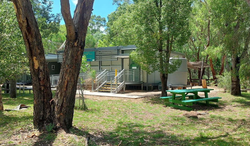 Exterior shot of Warrumbungle National Park Environmental Education Centre, showing outside picnic tables and an entrance to the centre. Credit and &copy; Warrumbungle National Park Environmental Education Centre 