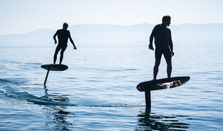 Two people surfing above still water on electric hydrofoil boards with Fliteschool Sydney. Credit and &copy; Fliteboard